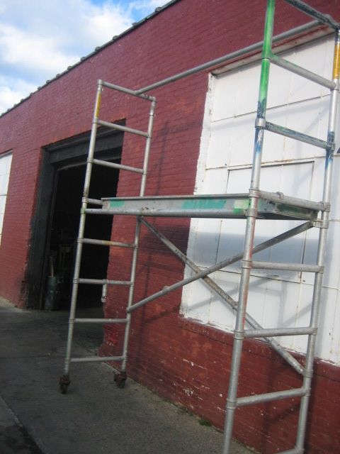 A ladder is leaning against a red brick building