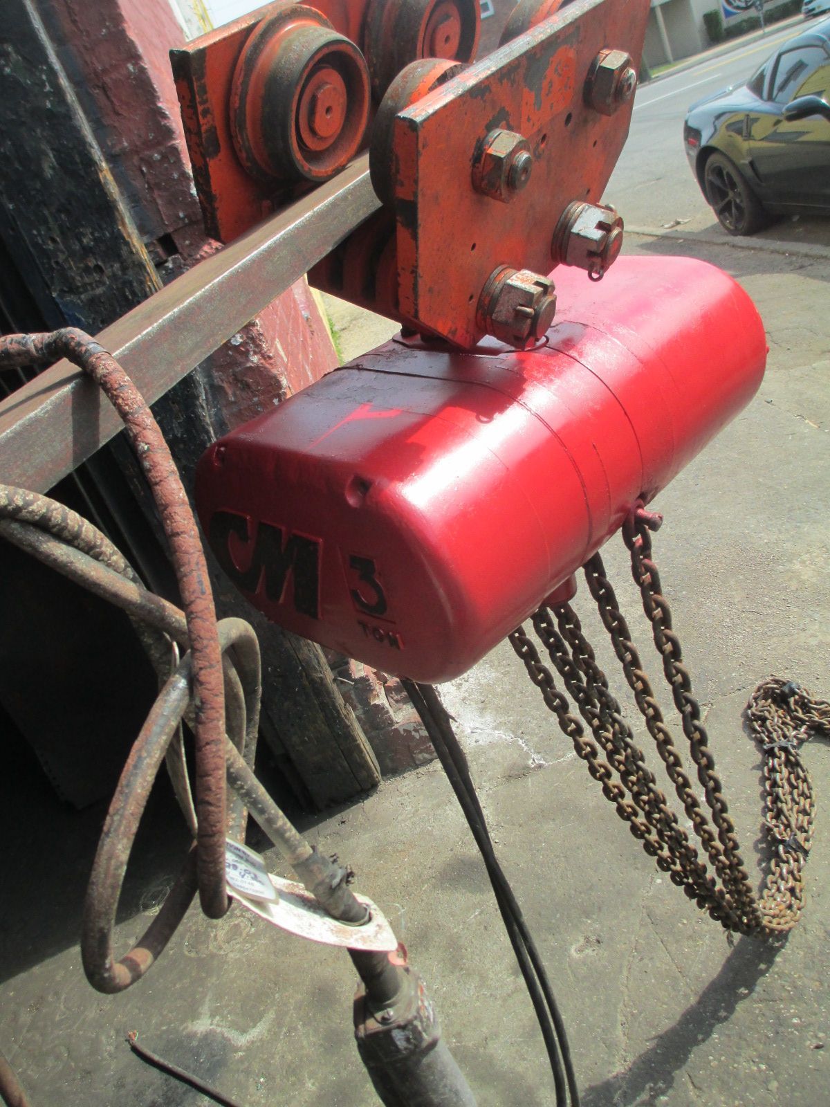 A red chain hoist with the word cm on it