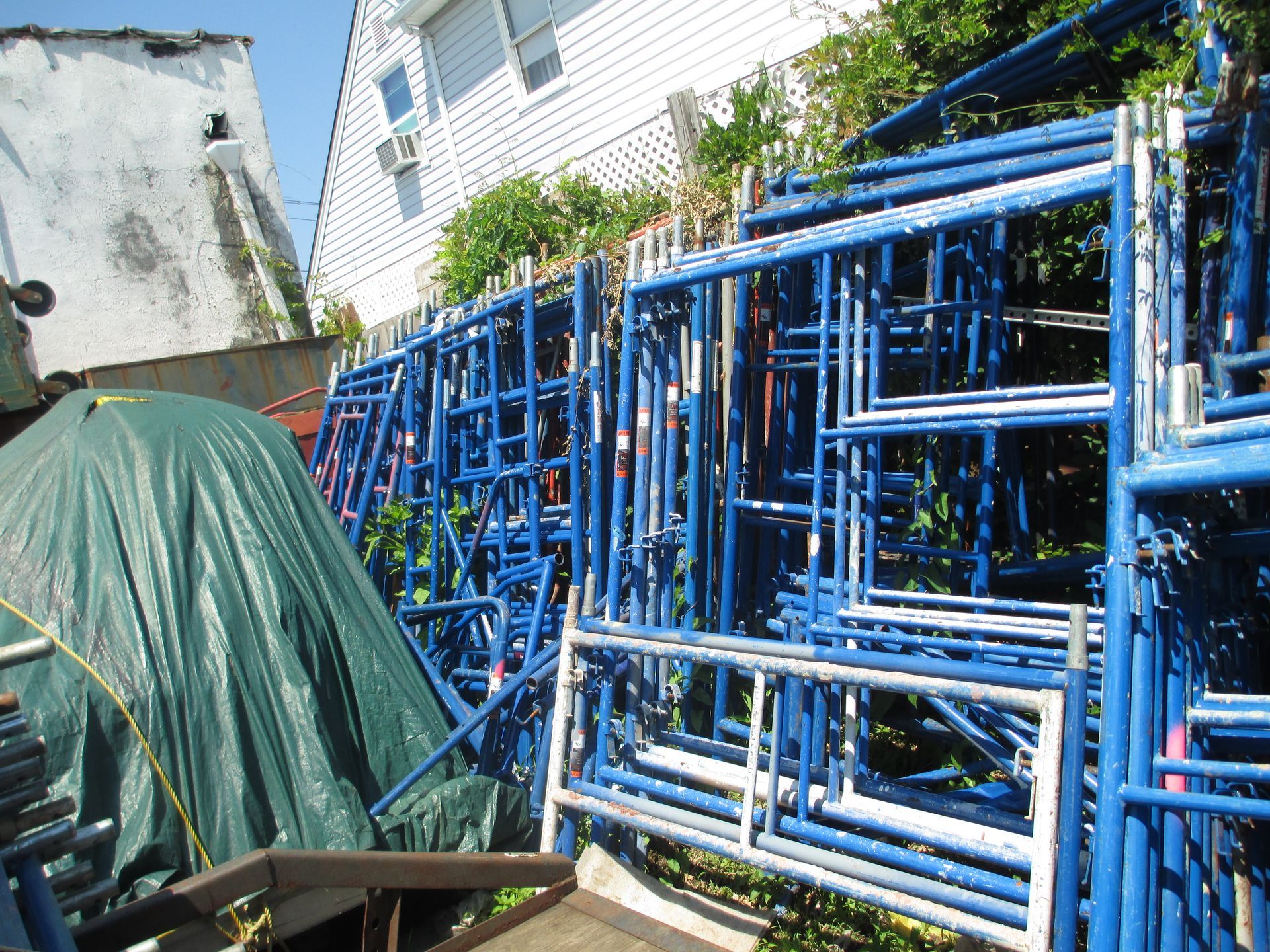A pile of blue scaffolding is stacked on top of each other
