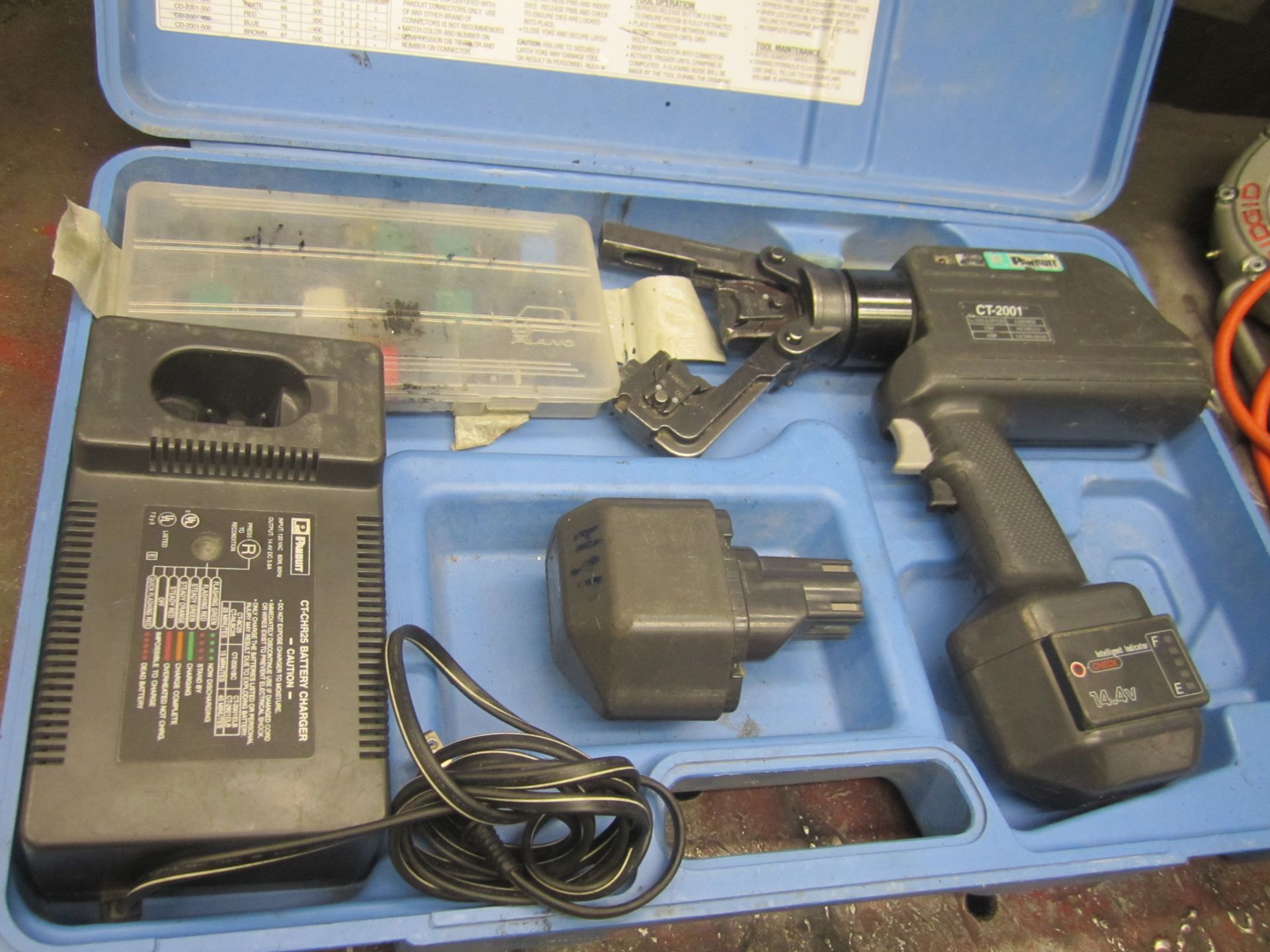 A cordless tool in a blue case with a charger