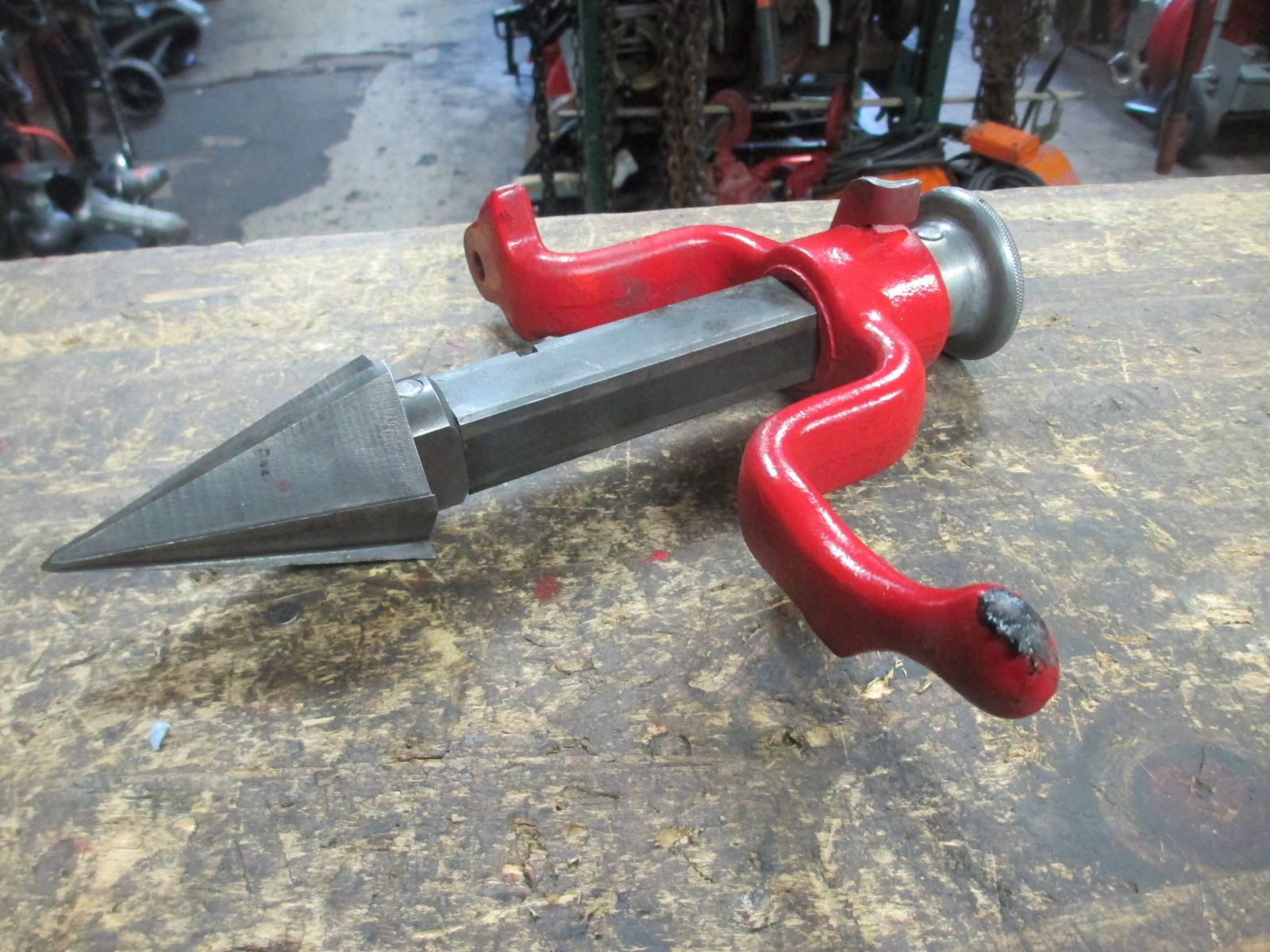 A red and black object is sitting on a wooden table.