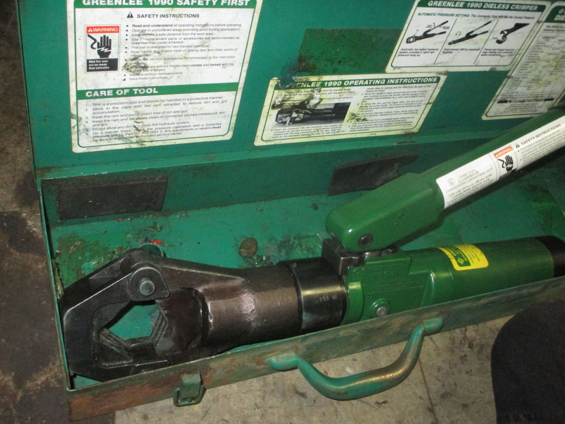 A green box with a tool in it that says ' hydraulic tool safety first ' on it