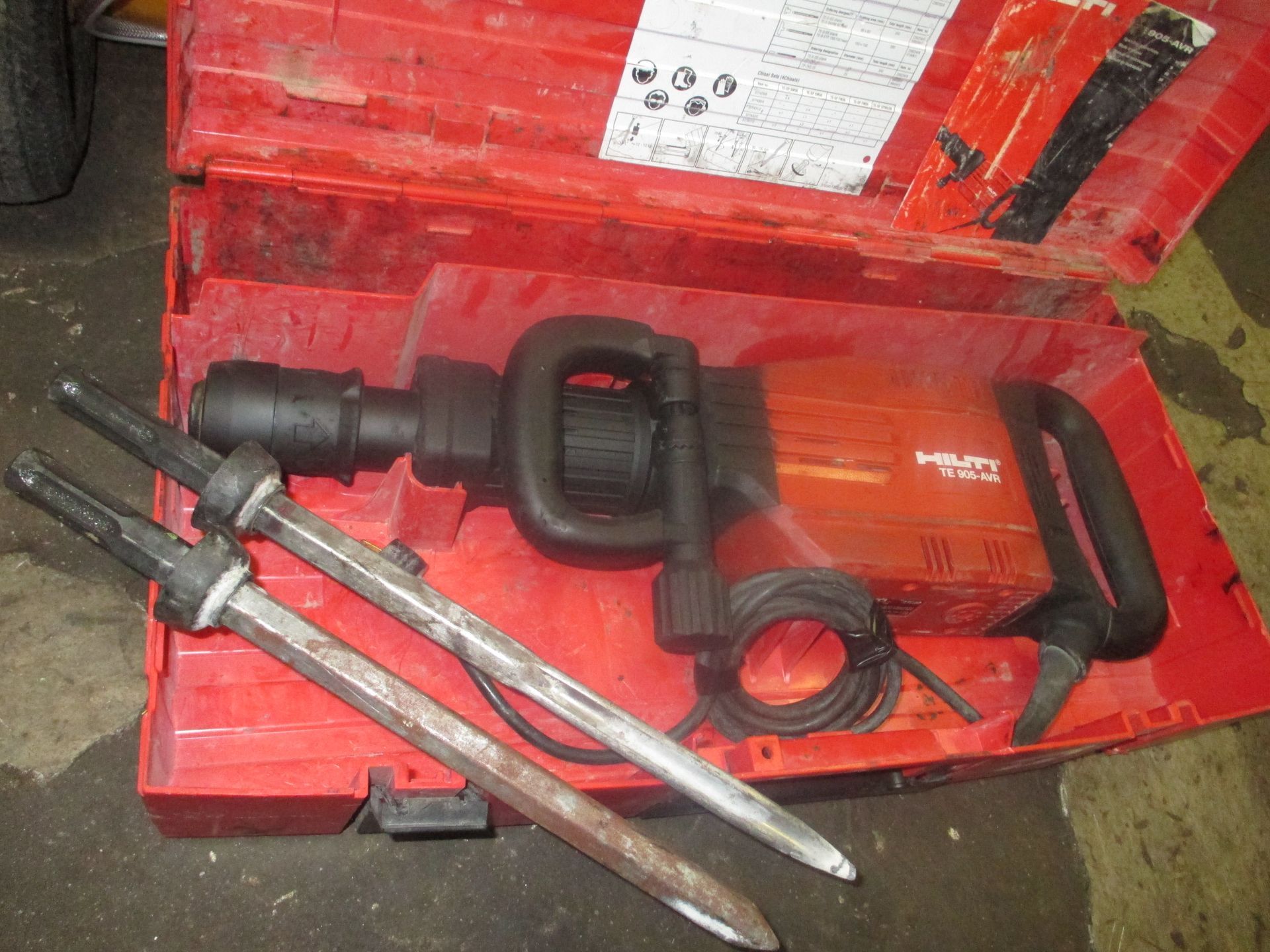 A red case with a hammer and two sticks inside of it