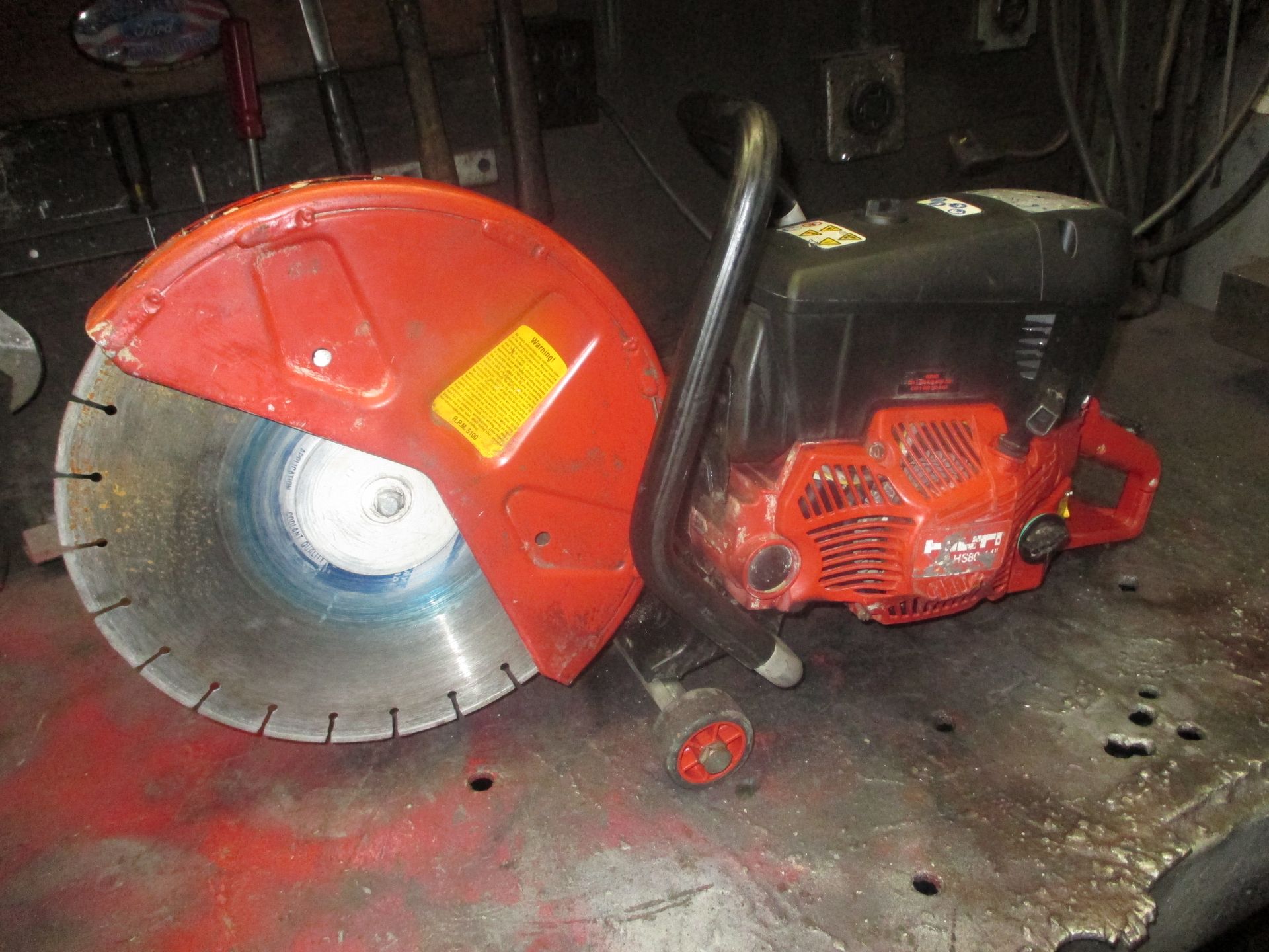 A red circular saw is sitting on a table.