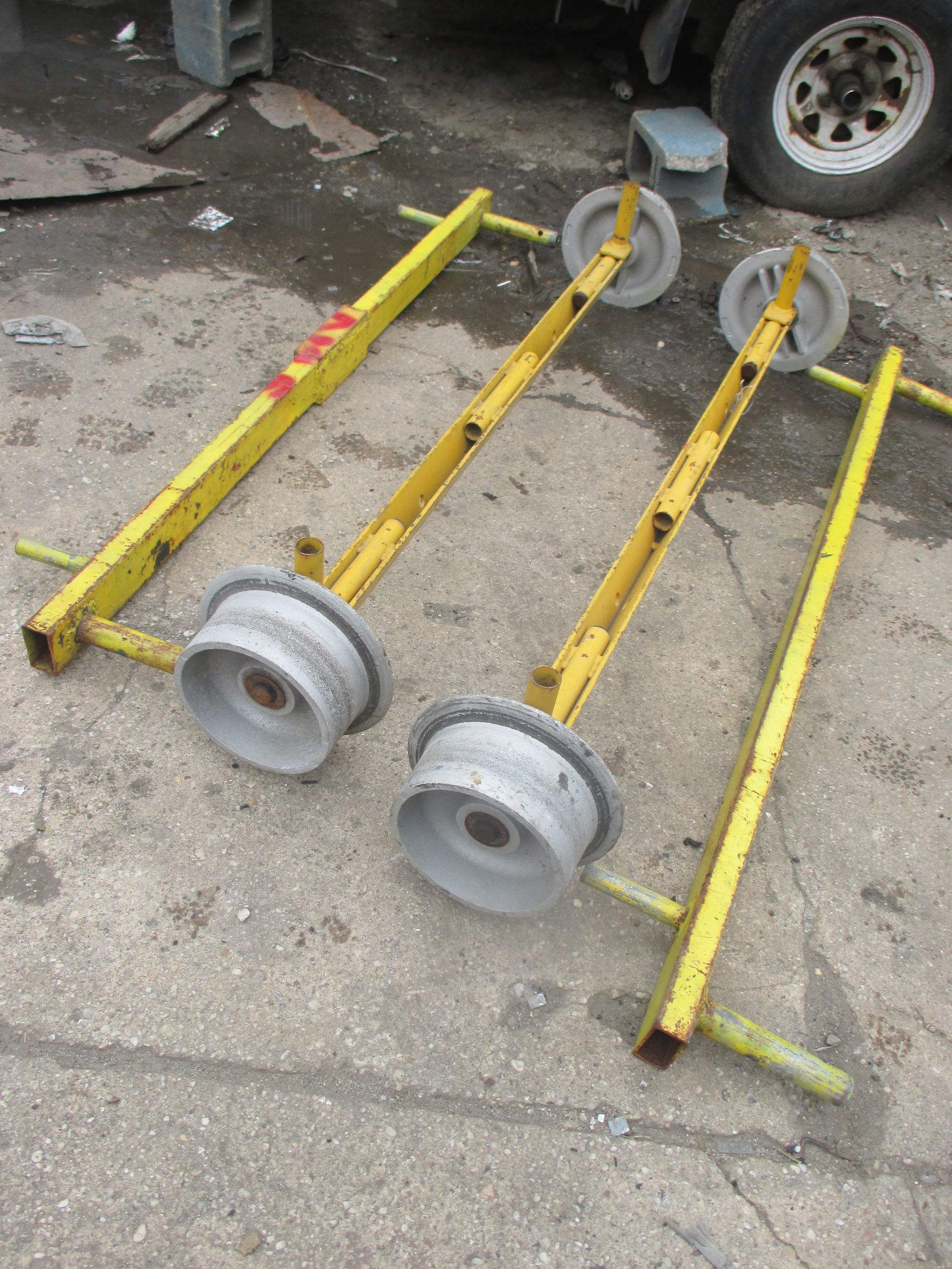 A pair of yellow wheels are sitting on a concrete surface