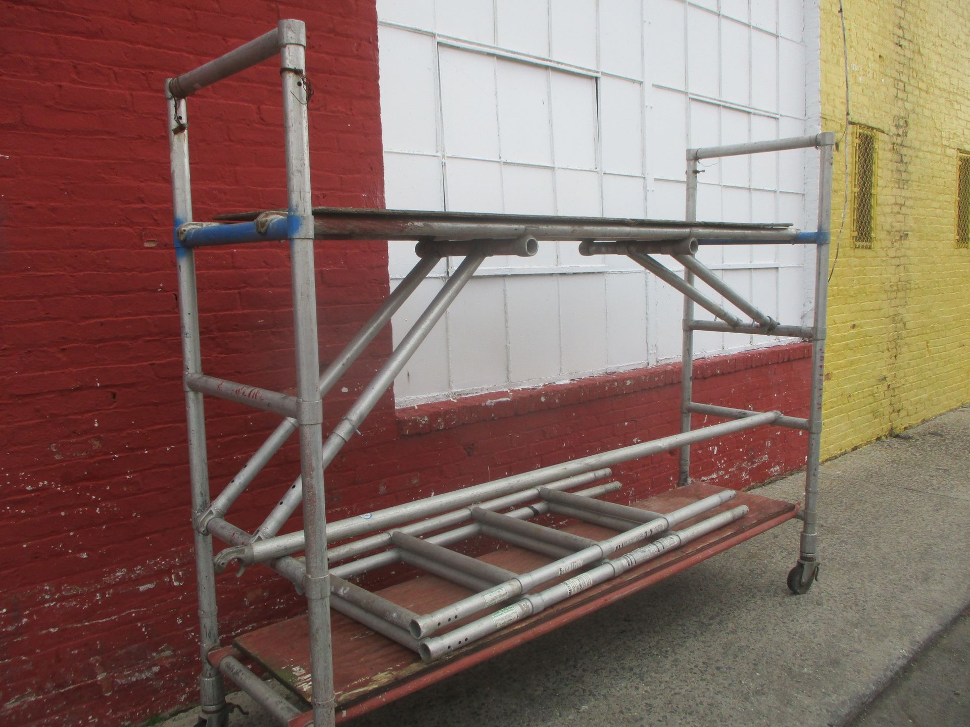A scaffolding is sitting in front of a red and white brick building