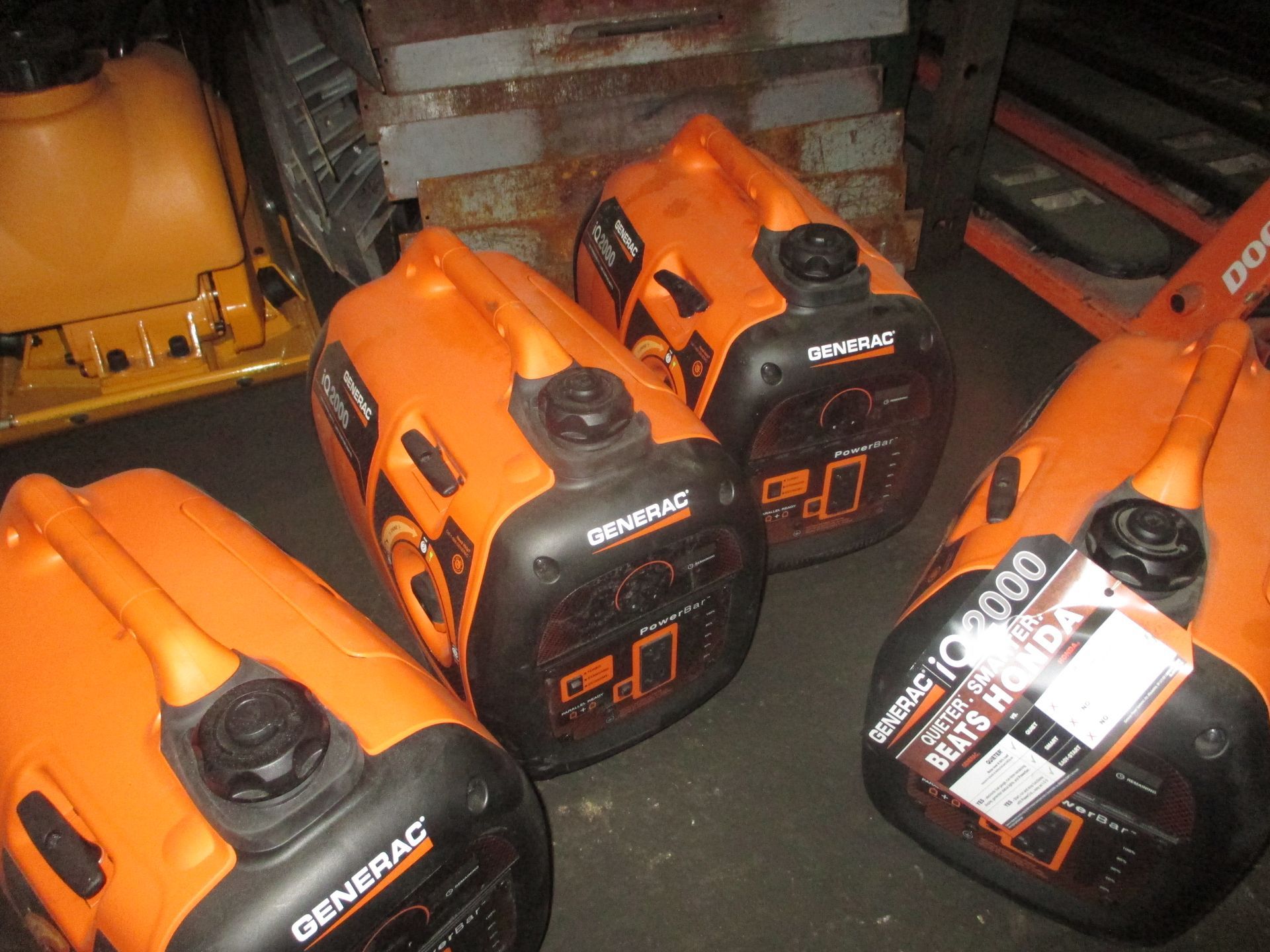 Several orange generators are sitting on the ground