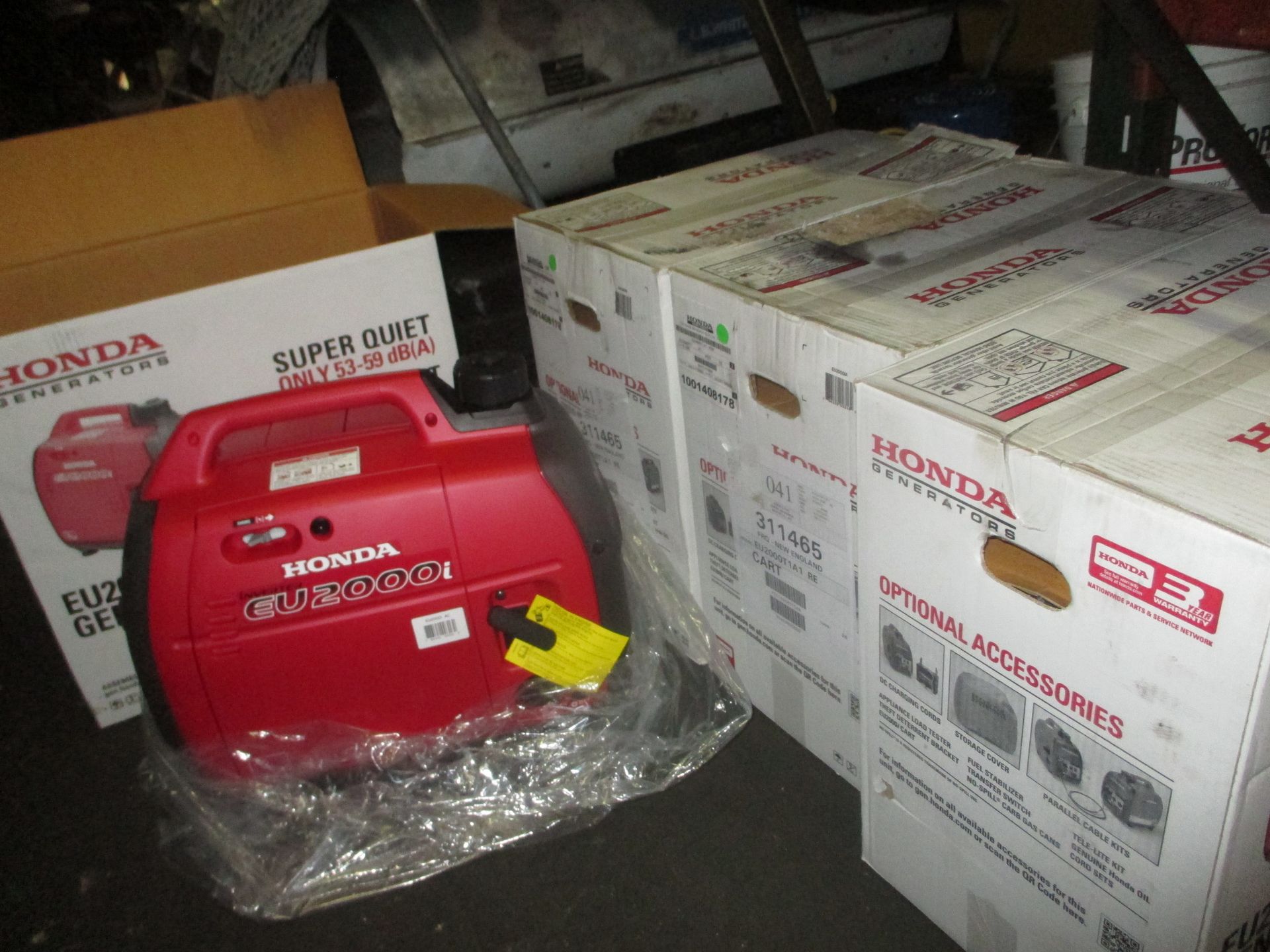 A red honda generator sits next to a stack of boxes