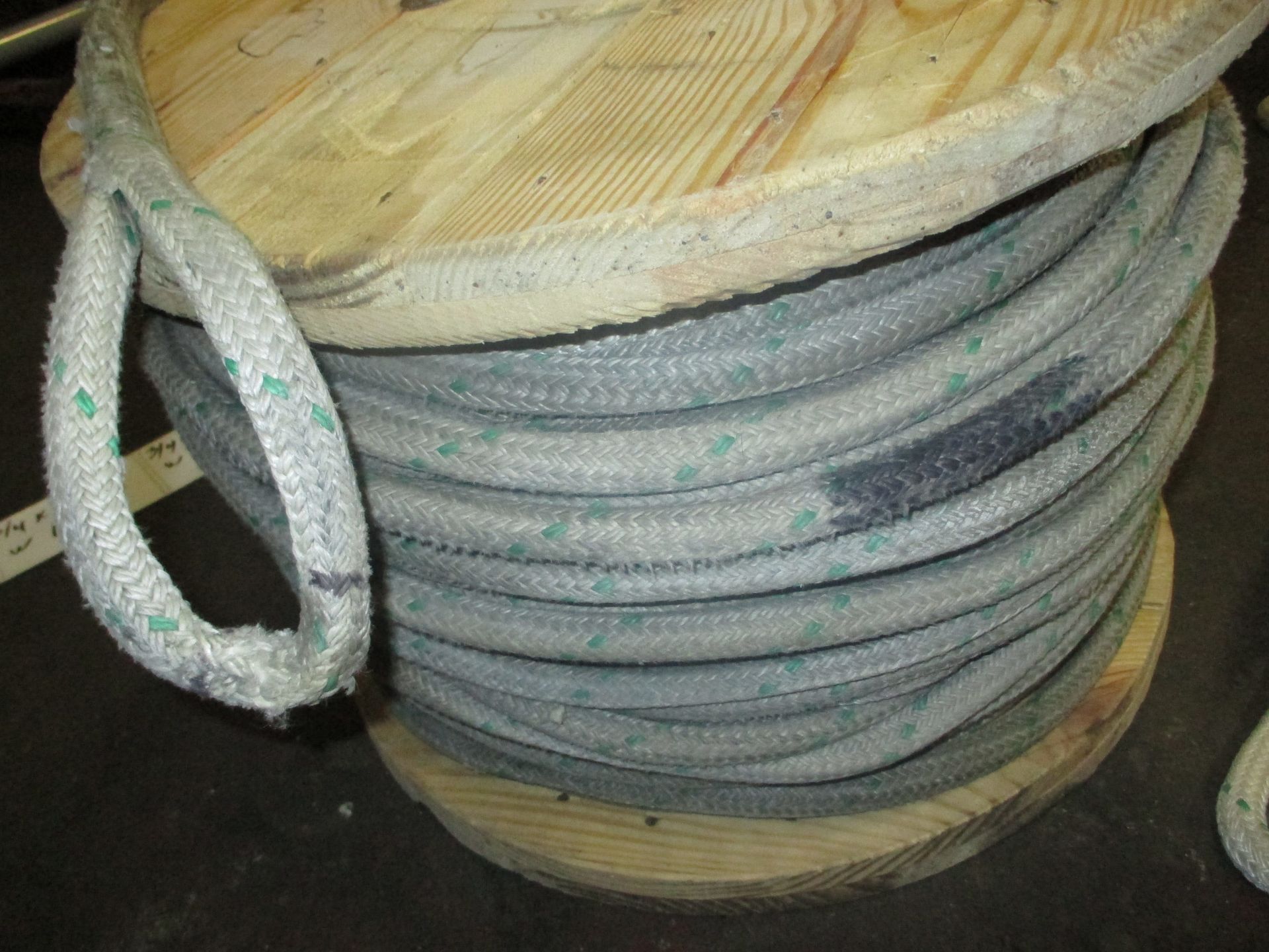 A spool of rope is sitting on a wooden spool