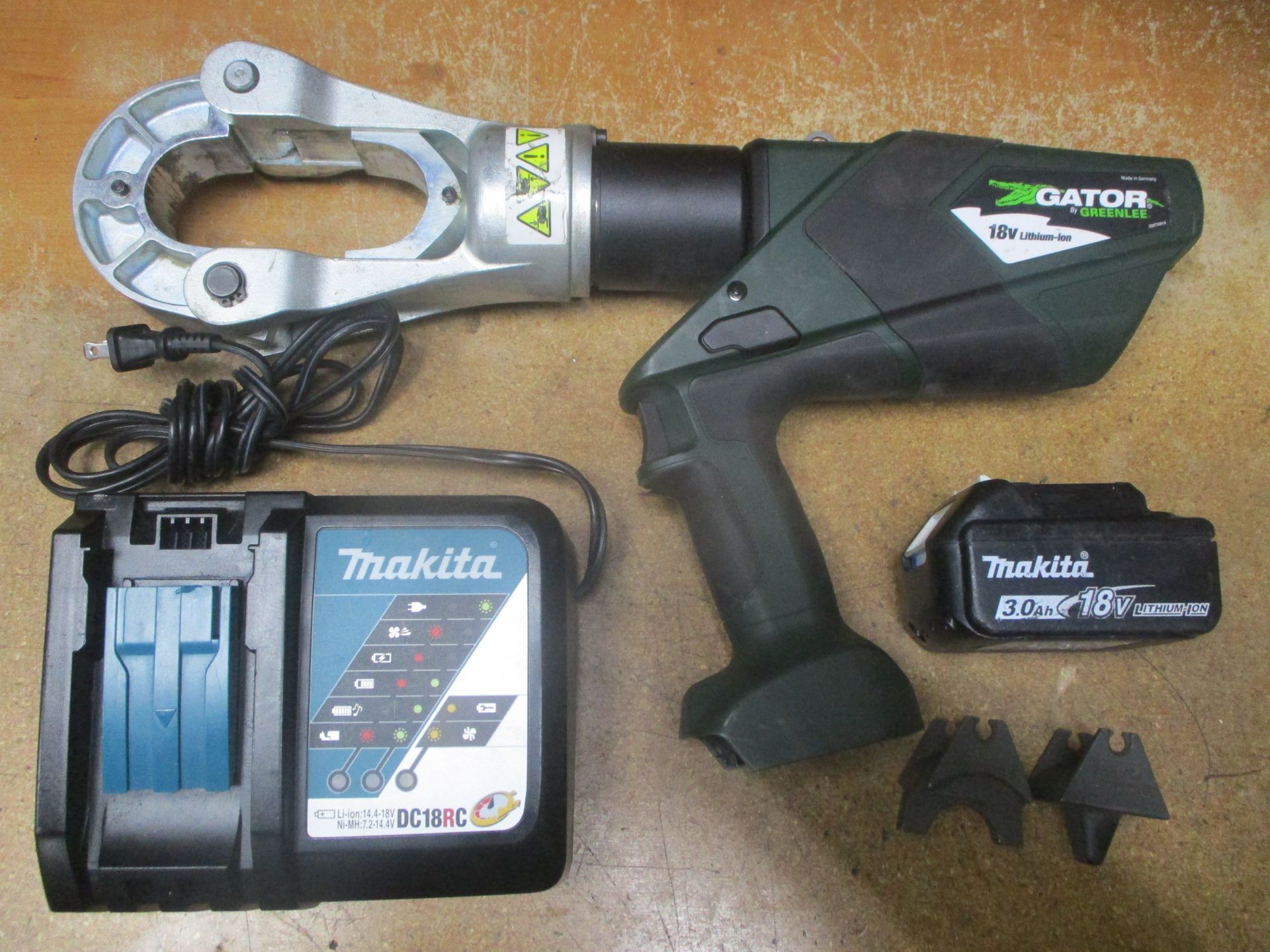 A makita tool is sitting next to a makita charger.
