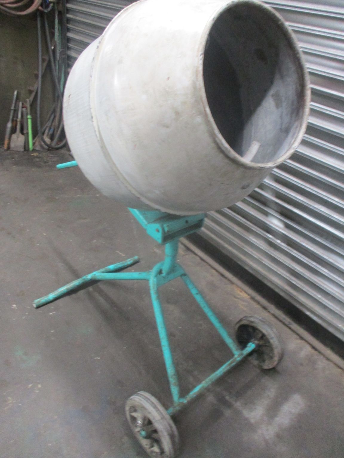 A cement mixer is sitting on a green stand