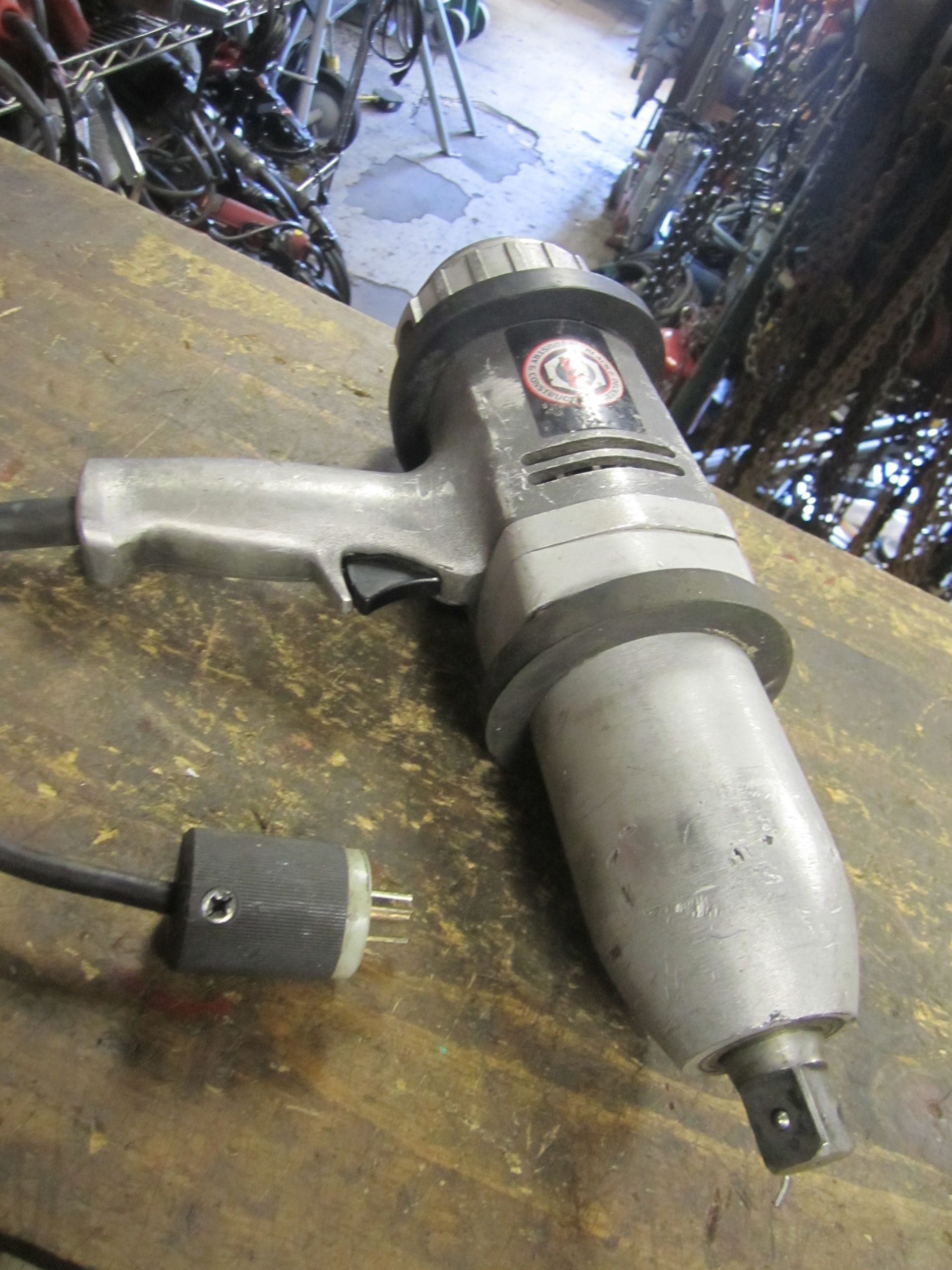 An electric wrench is sitting on a wooden table.