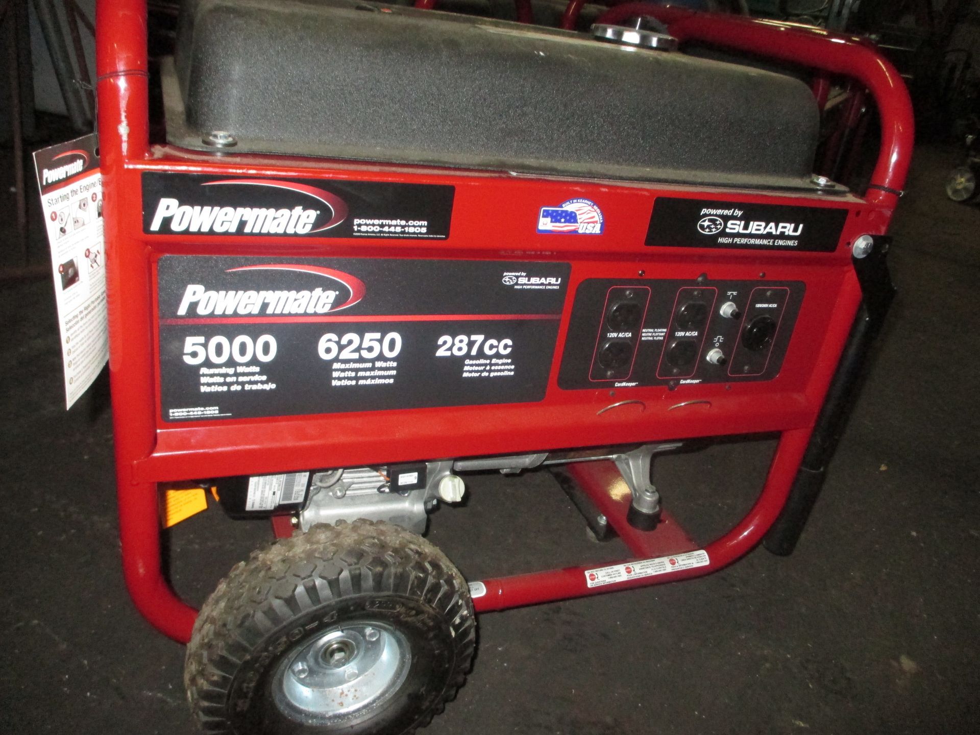 A red powermate generator is sitting on the ground