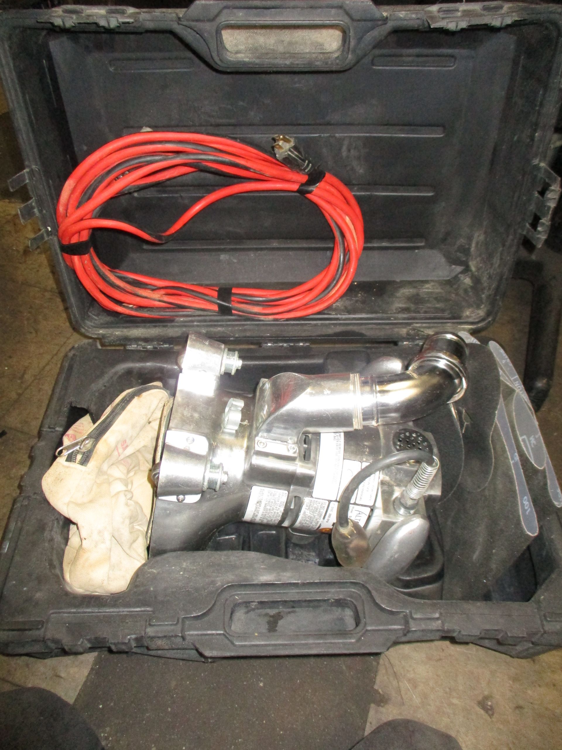 A tool in a case with a red cord attached to it