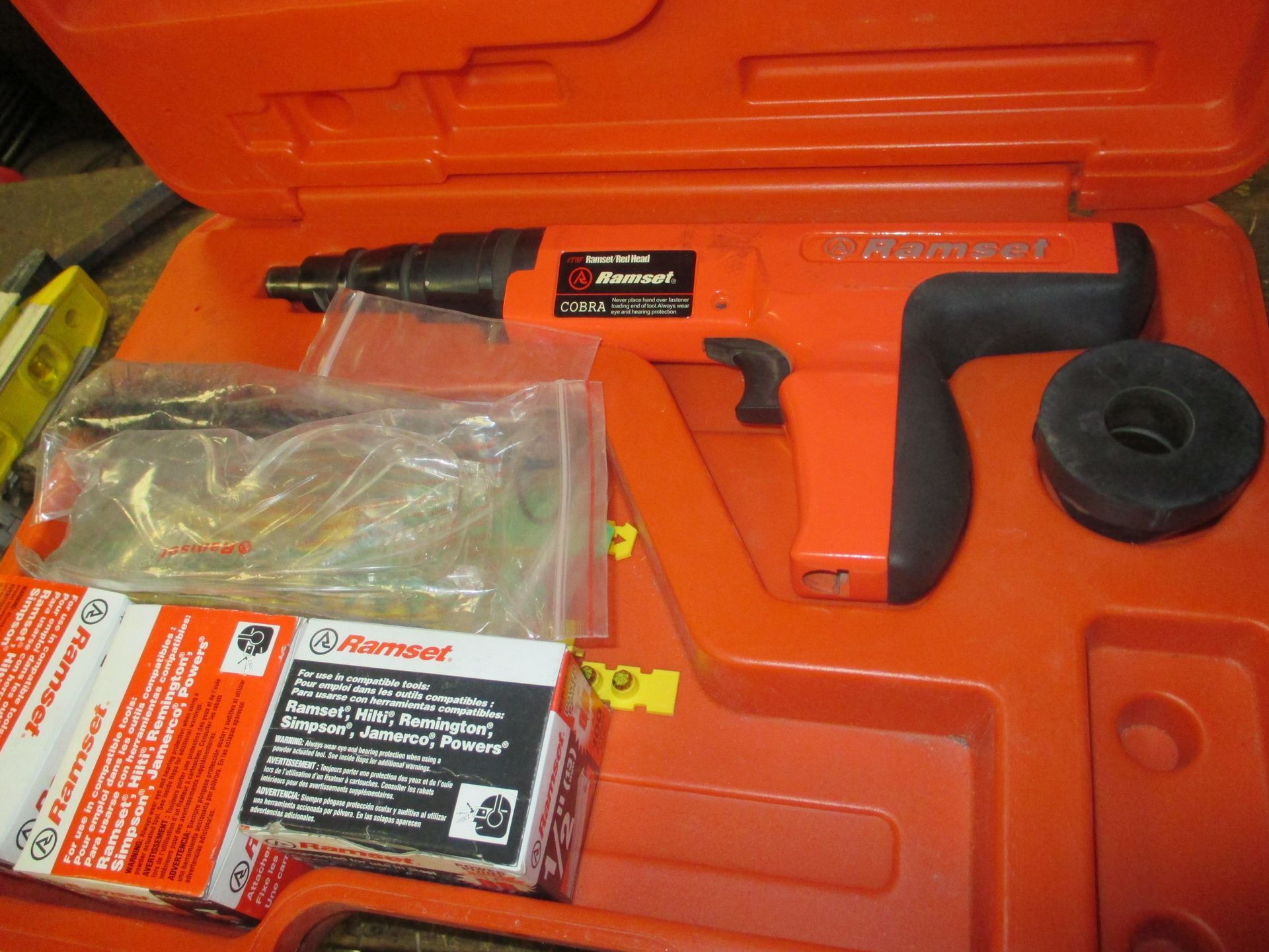 An orange case with a hammer and nails in it