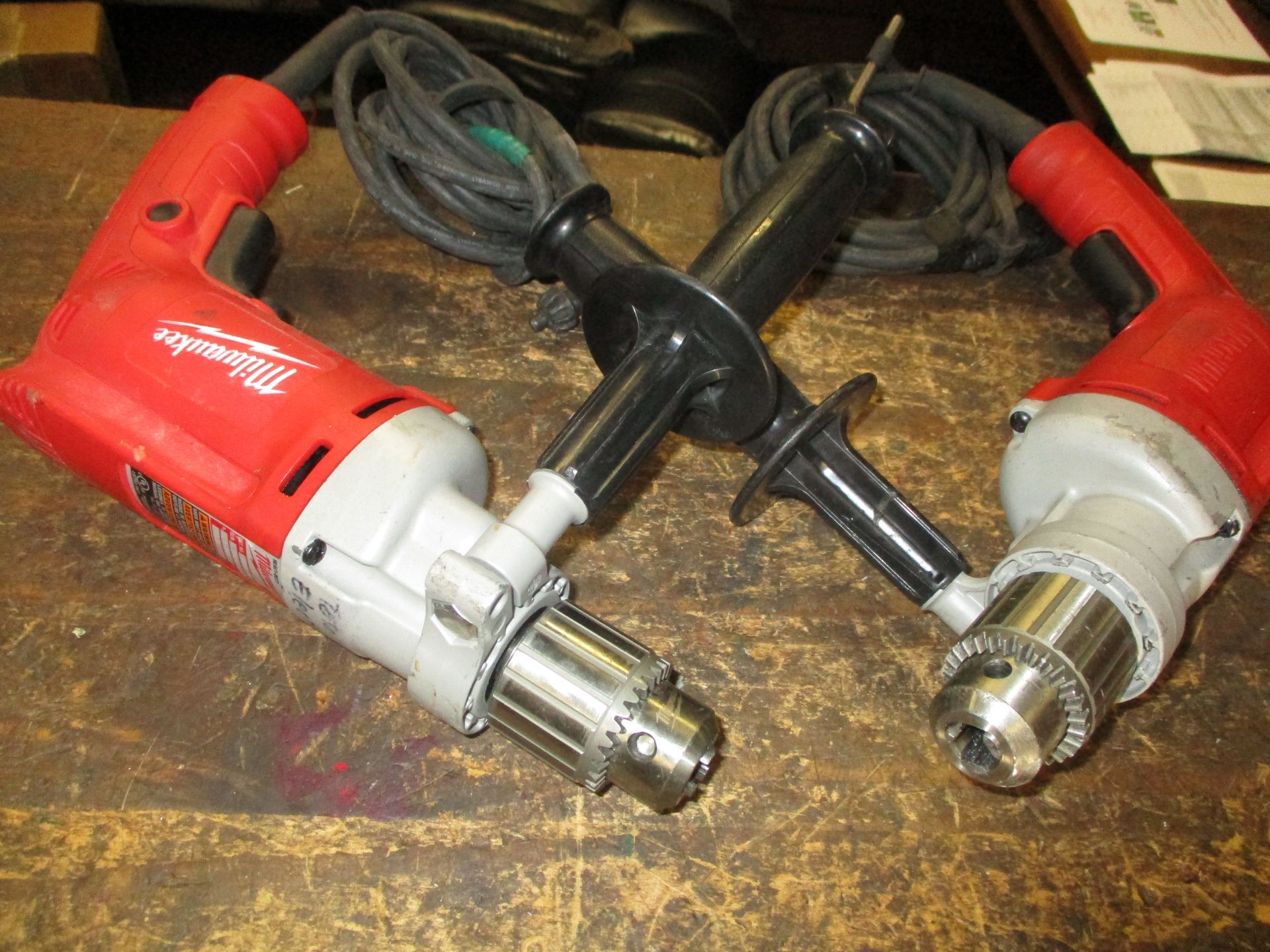 Two milwaukee drills are sitting on a wooden table