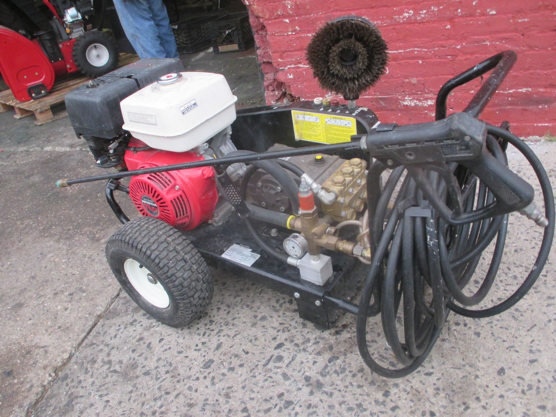 A gas powered high pressure washer with a hose attached to it