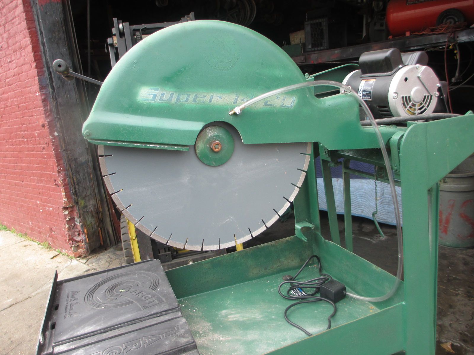 A green circular saw with a motor attached to it