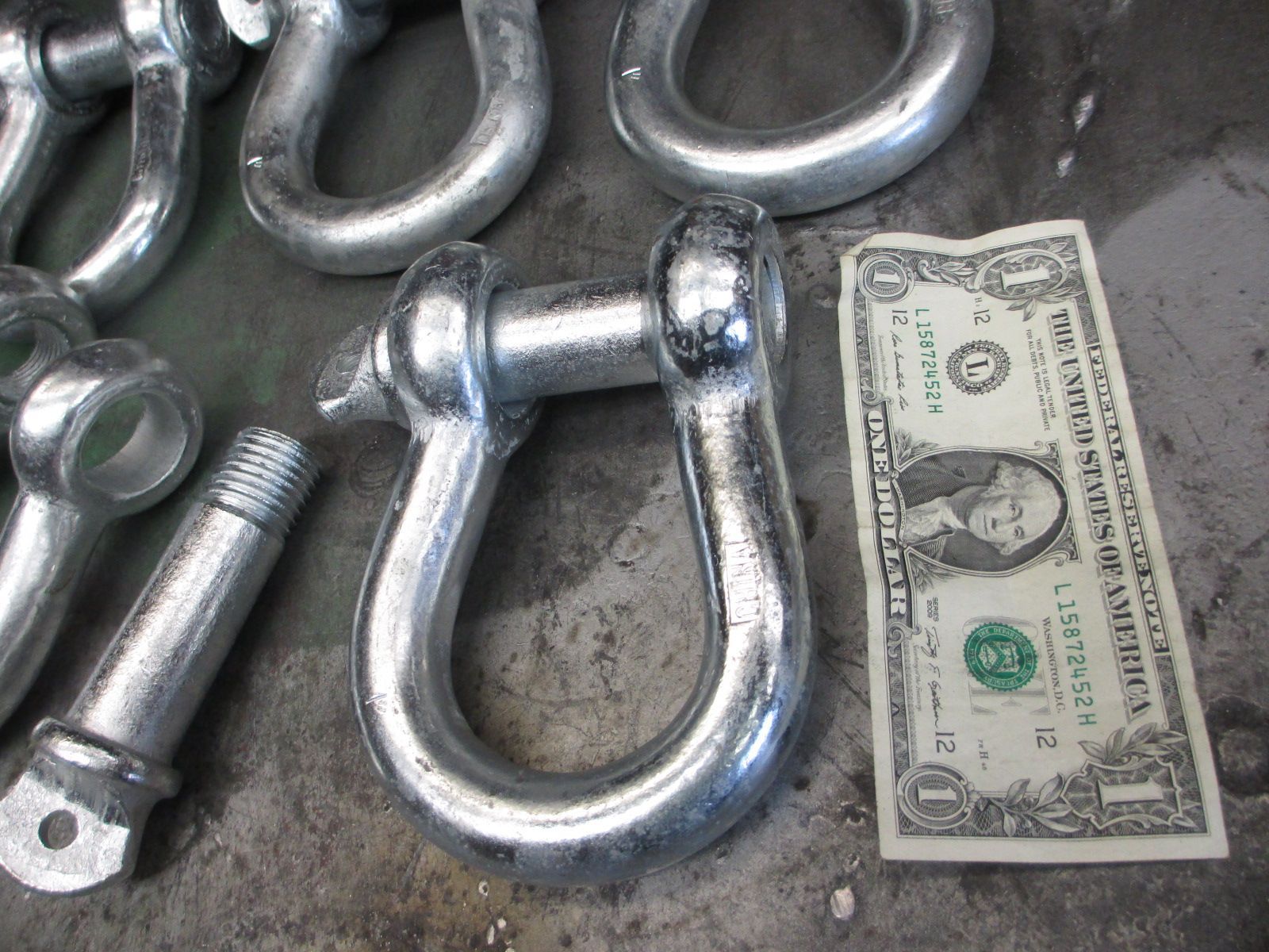 A 1 dollar bill is sitting next to a bunch of metal hooks