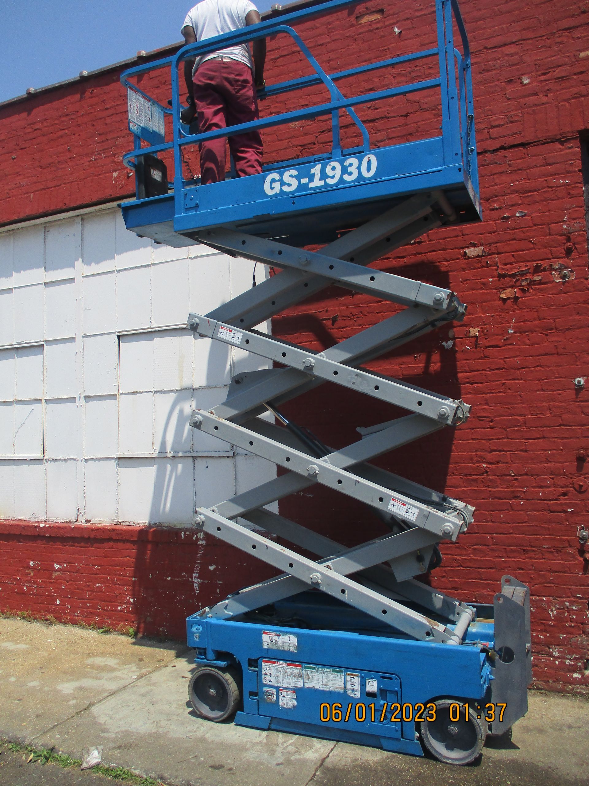 A man is standing on a gs 1930 scissor lift