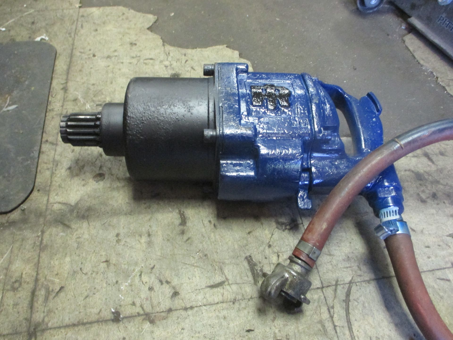 A blue and black machine with a hose attached to it