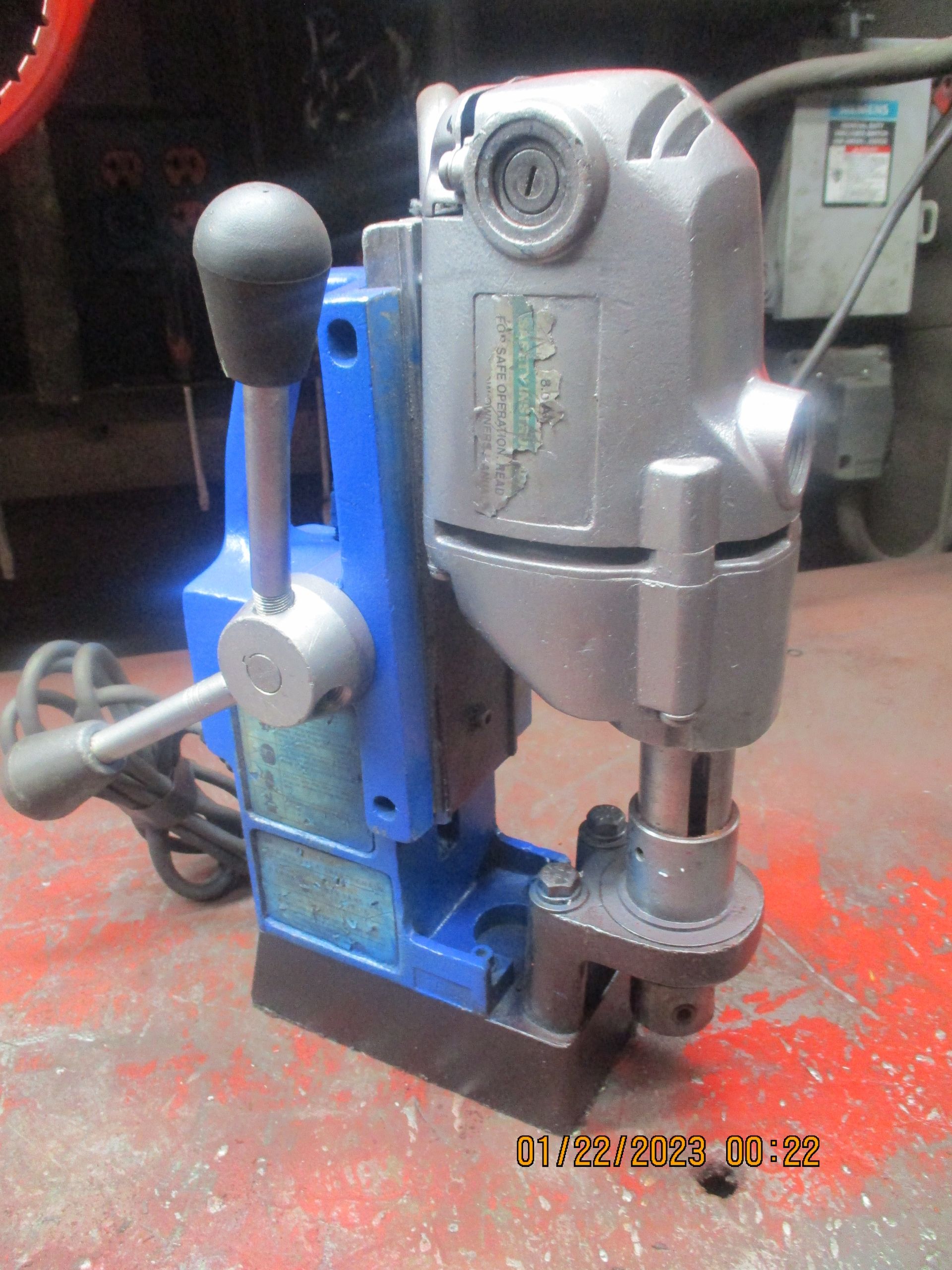 A blue and gray machine is sitting on a red surface.