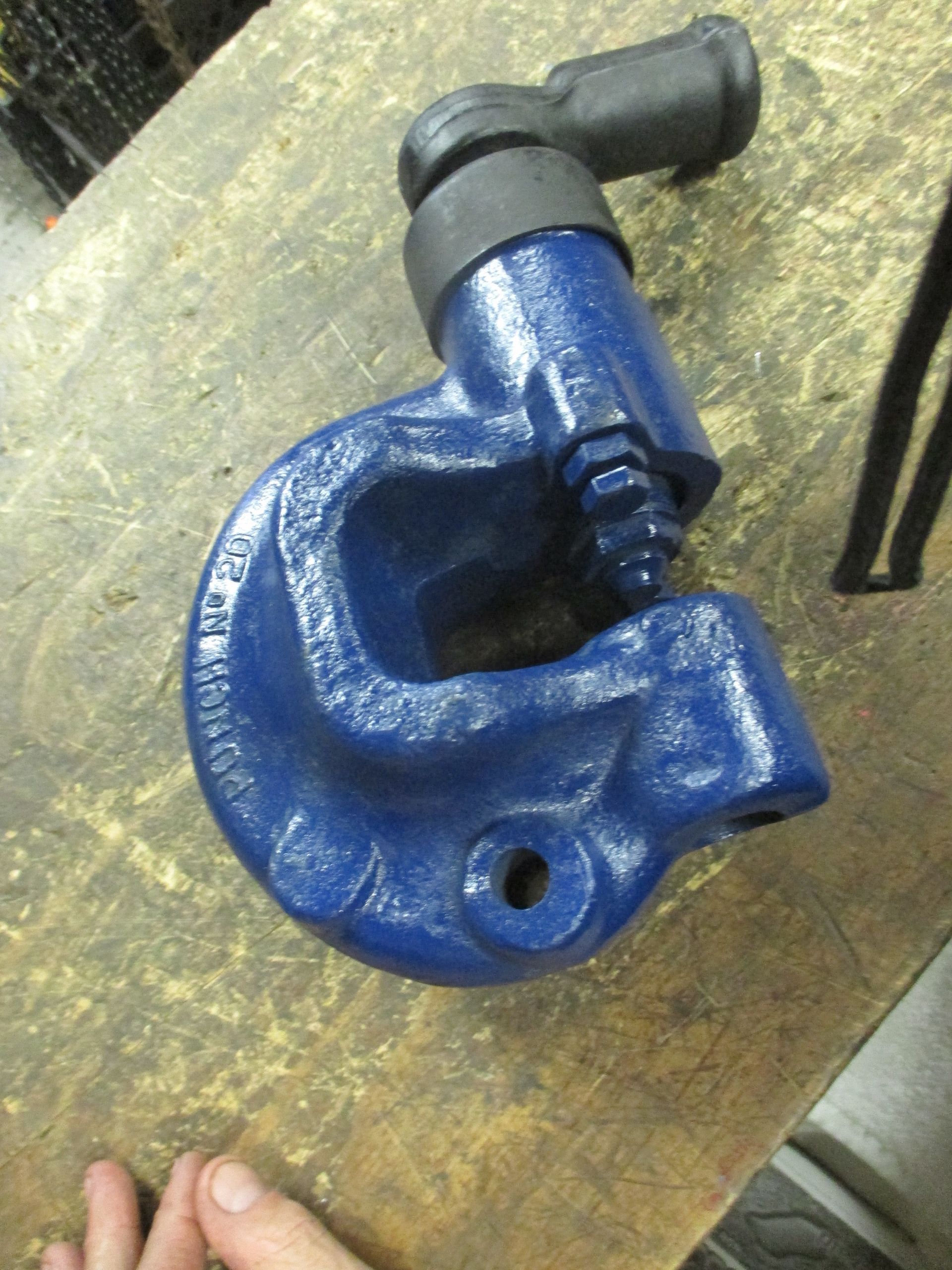 A blue tool is sitting on a wooden table.