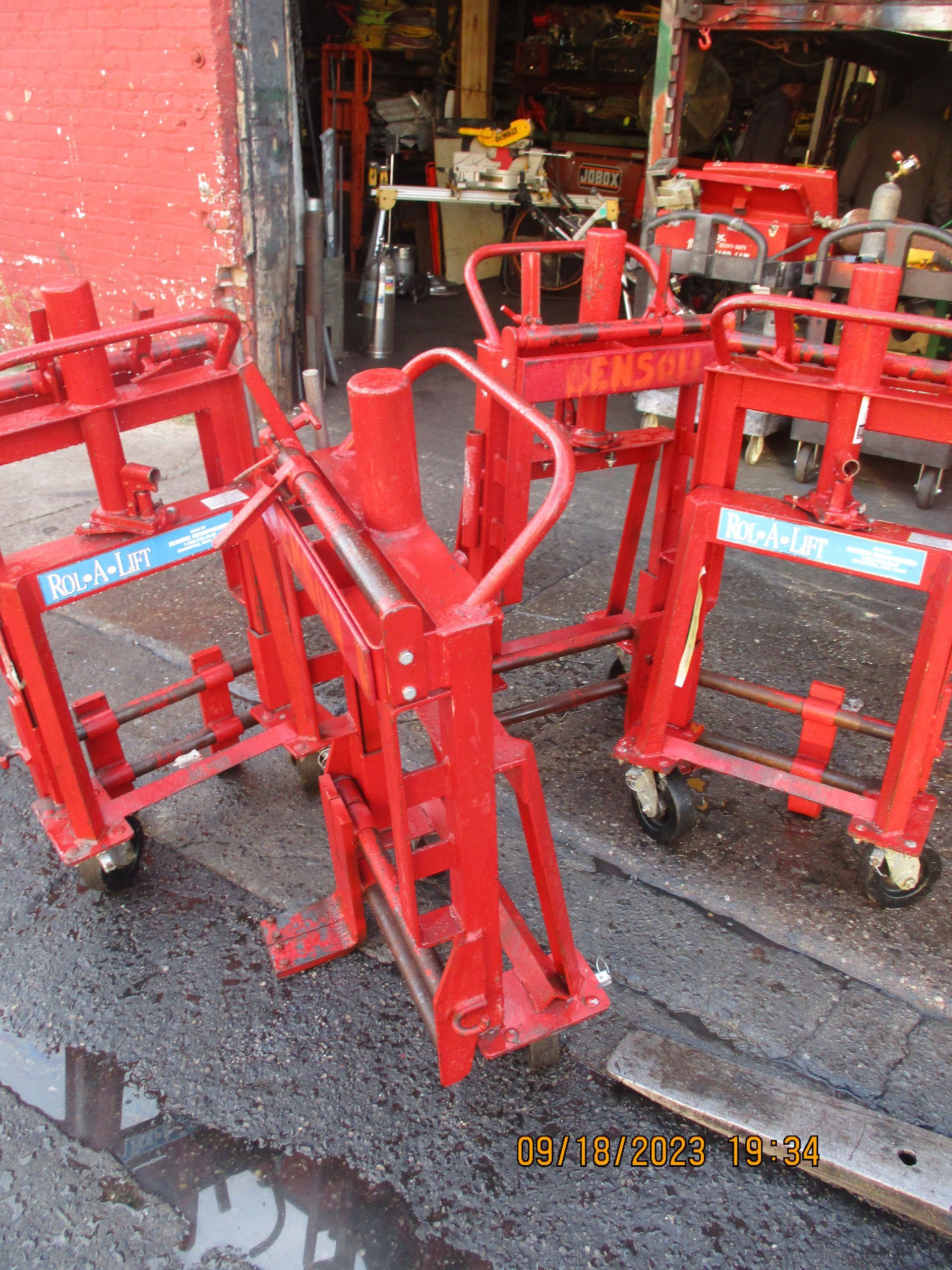 A bunch of red forklifts are sitting in front of a red building