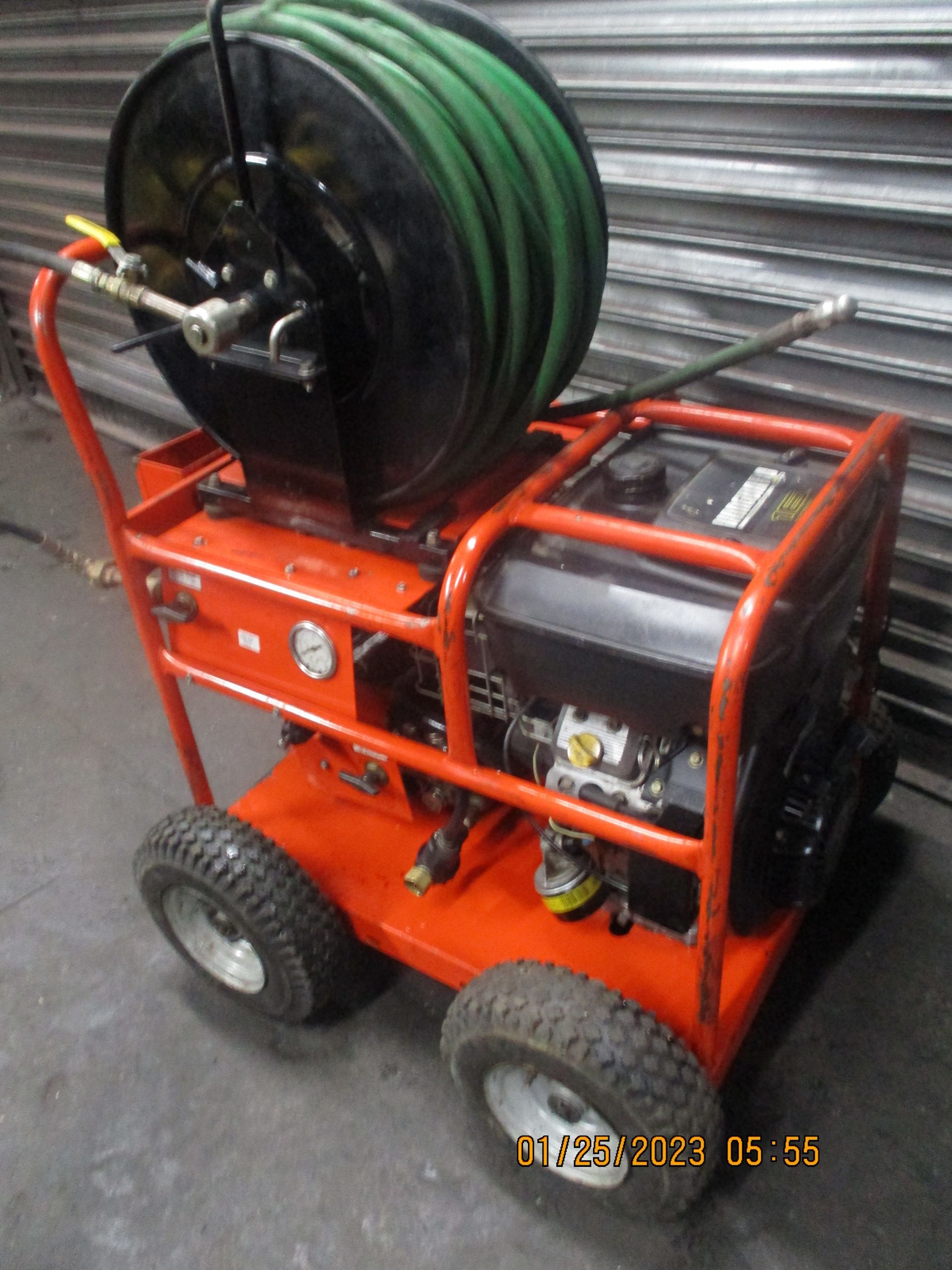 An orange machine with a green hose attached to it