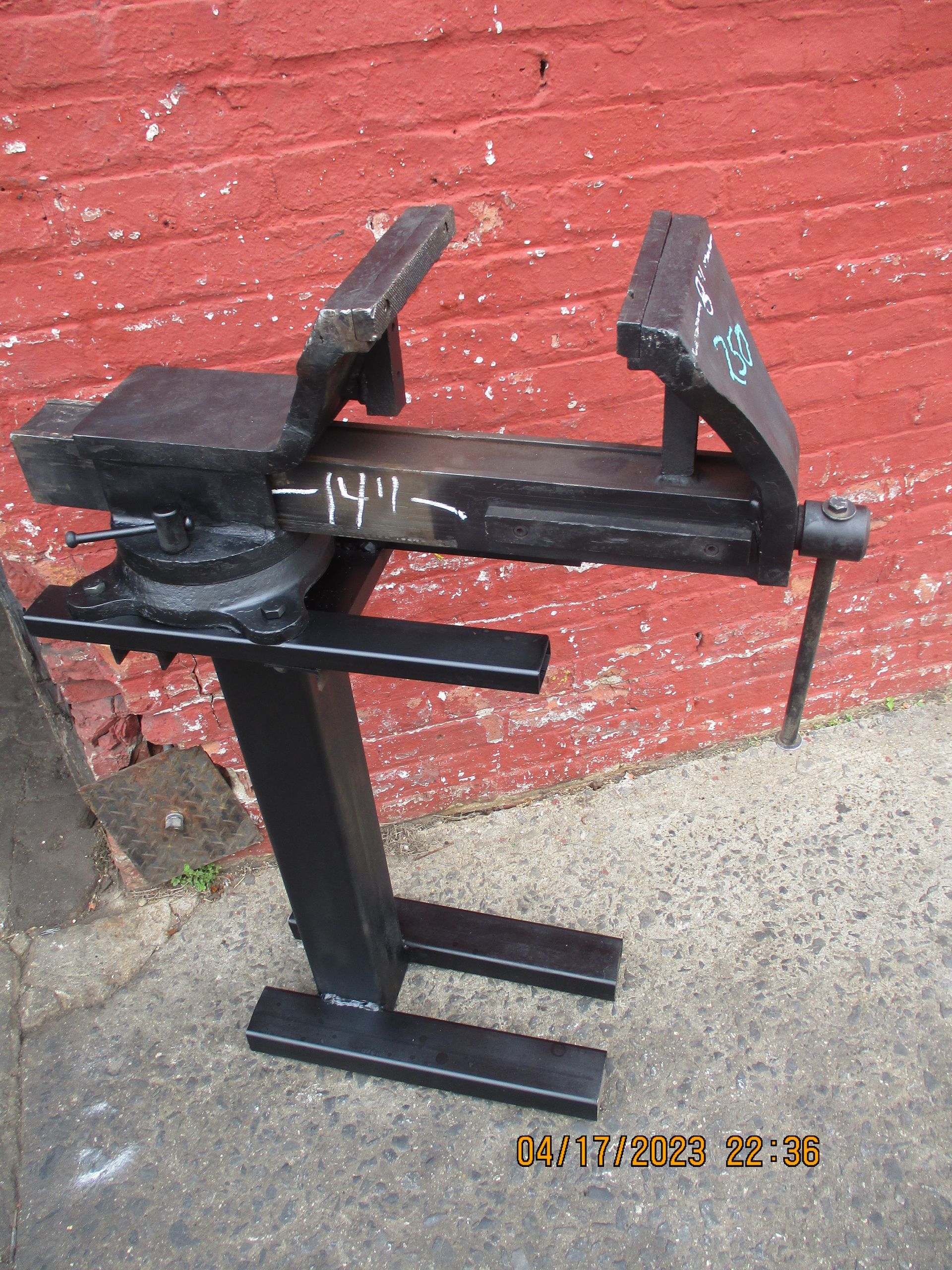 A brick wall behind a vise that says ' n11 ' on it
