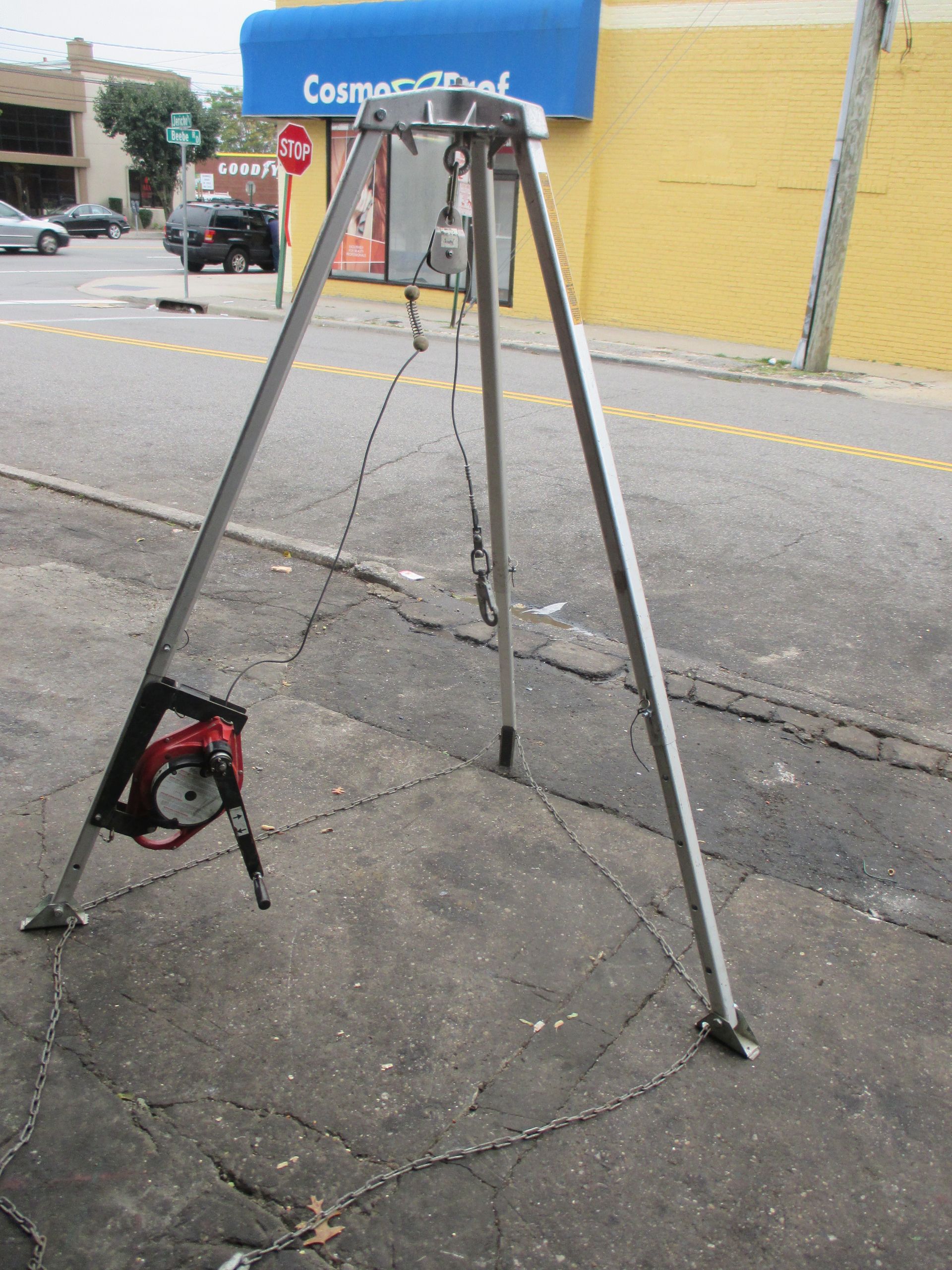 A tripod is sitting on the sidewalk in front of a commercial bank