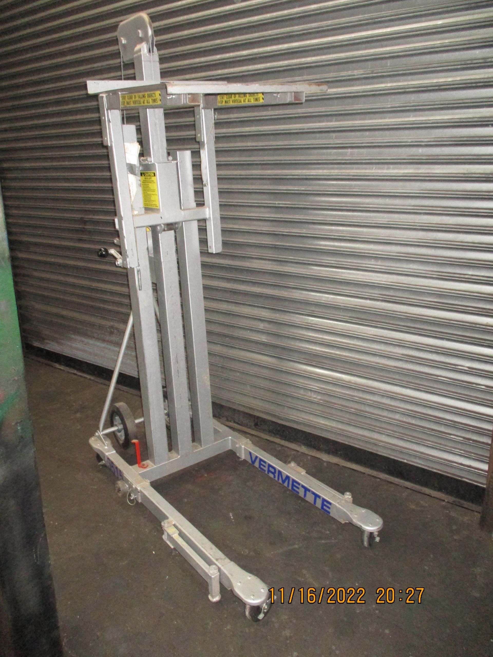 A metal lift is sitting in front of a metal shutter.