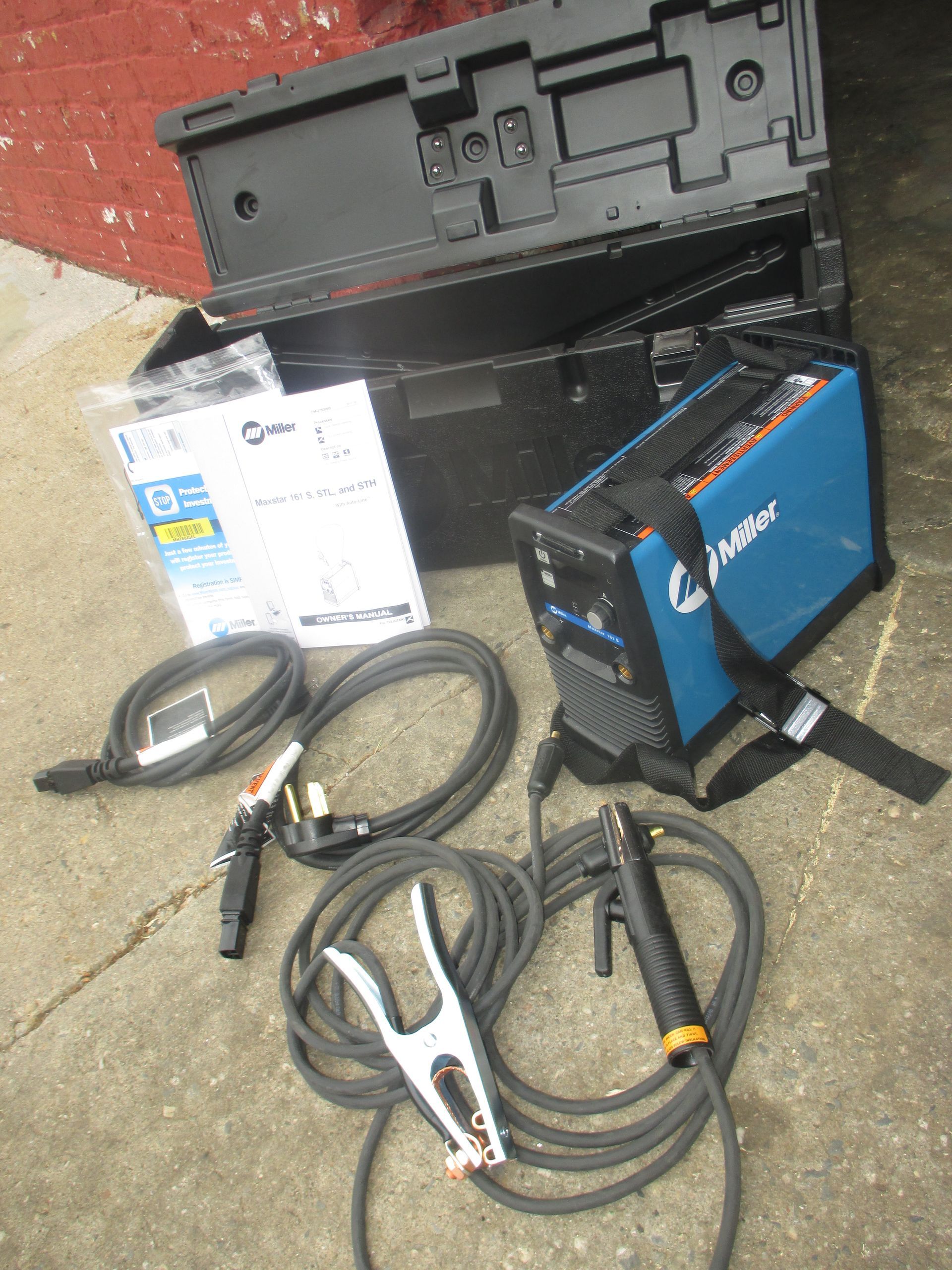 A welding machine is sitting on the ground next to a box