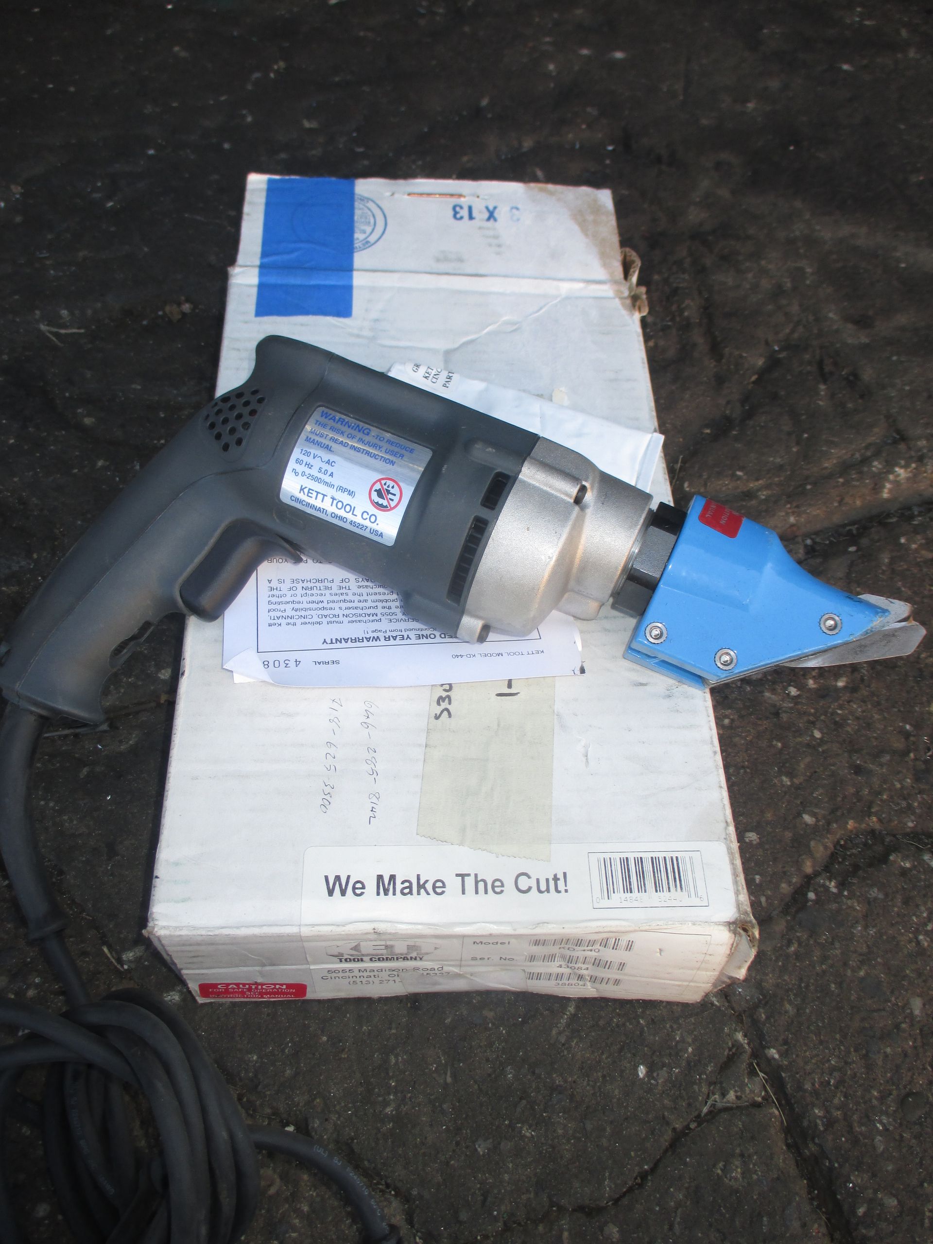 A drill is sitting on top of a box that says we make the cut