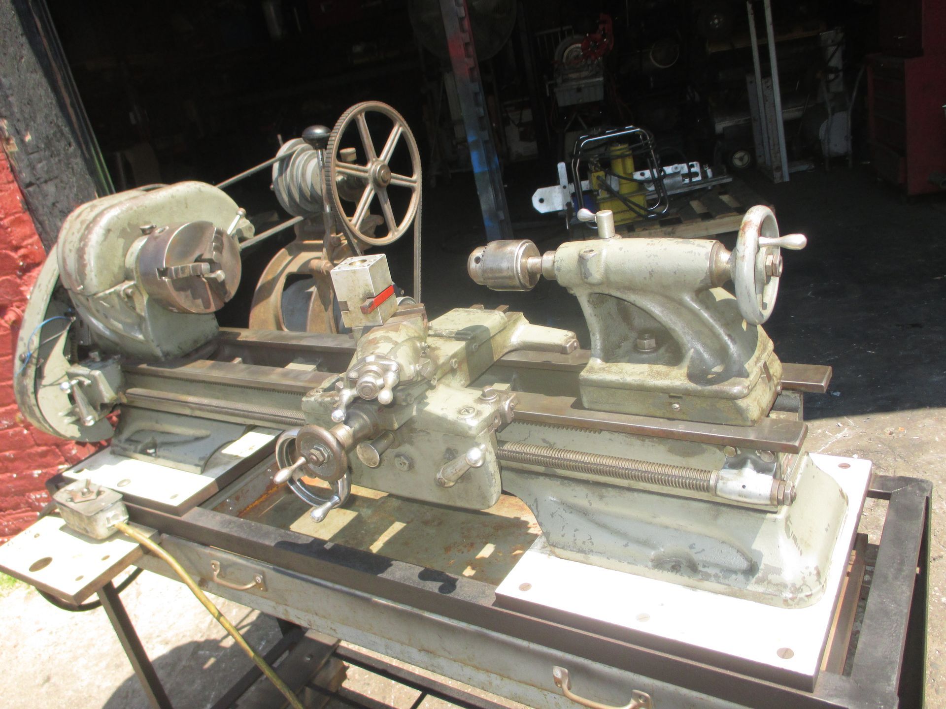 A lathe is sitting on a table in a garage.