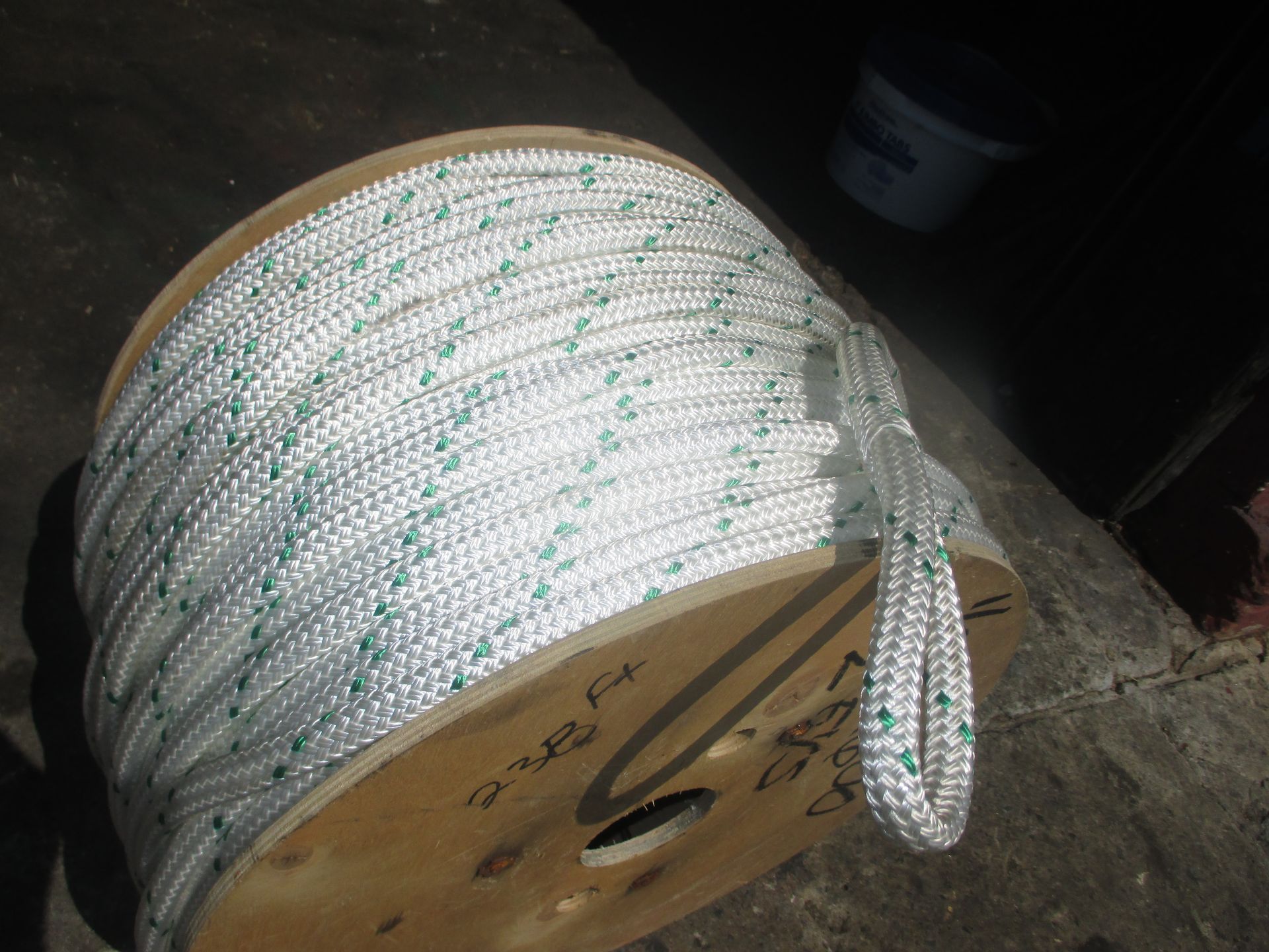 A spool of white rope with green spots on it