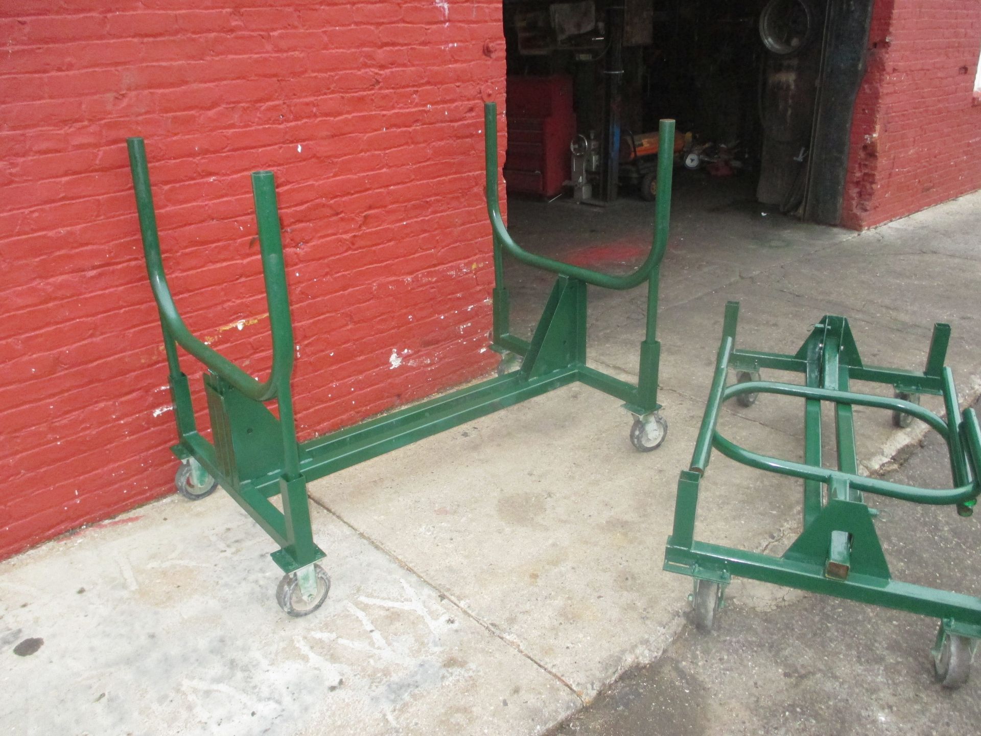 Two green carts are parked in front of a red brick building