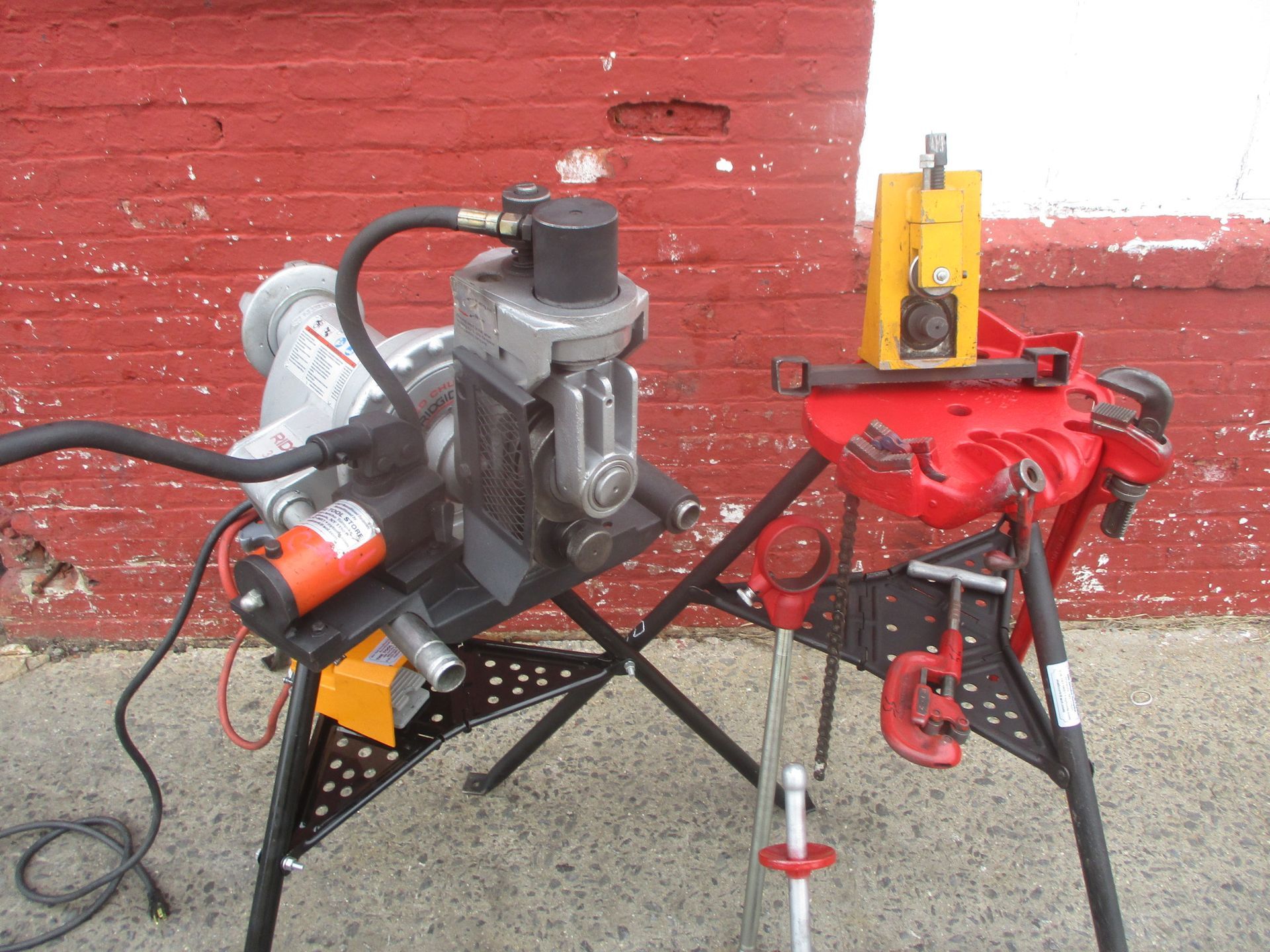 A machine is sitting on a table in front of a red brick wall