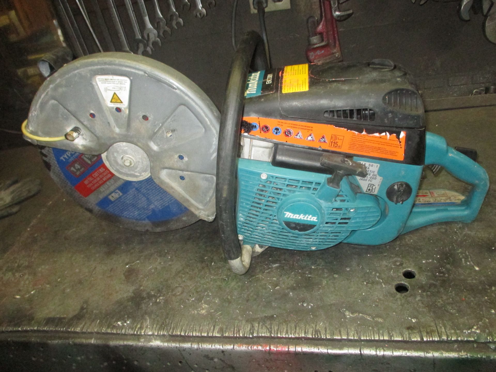 A makita chainsaw is sitting on a table.