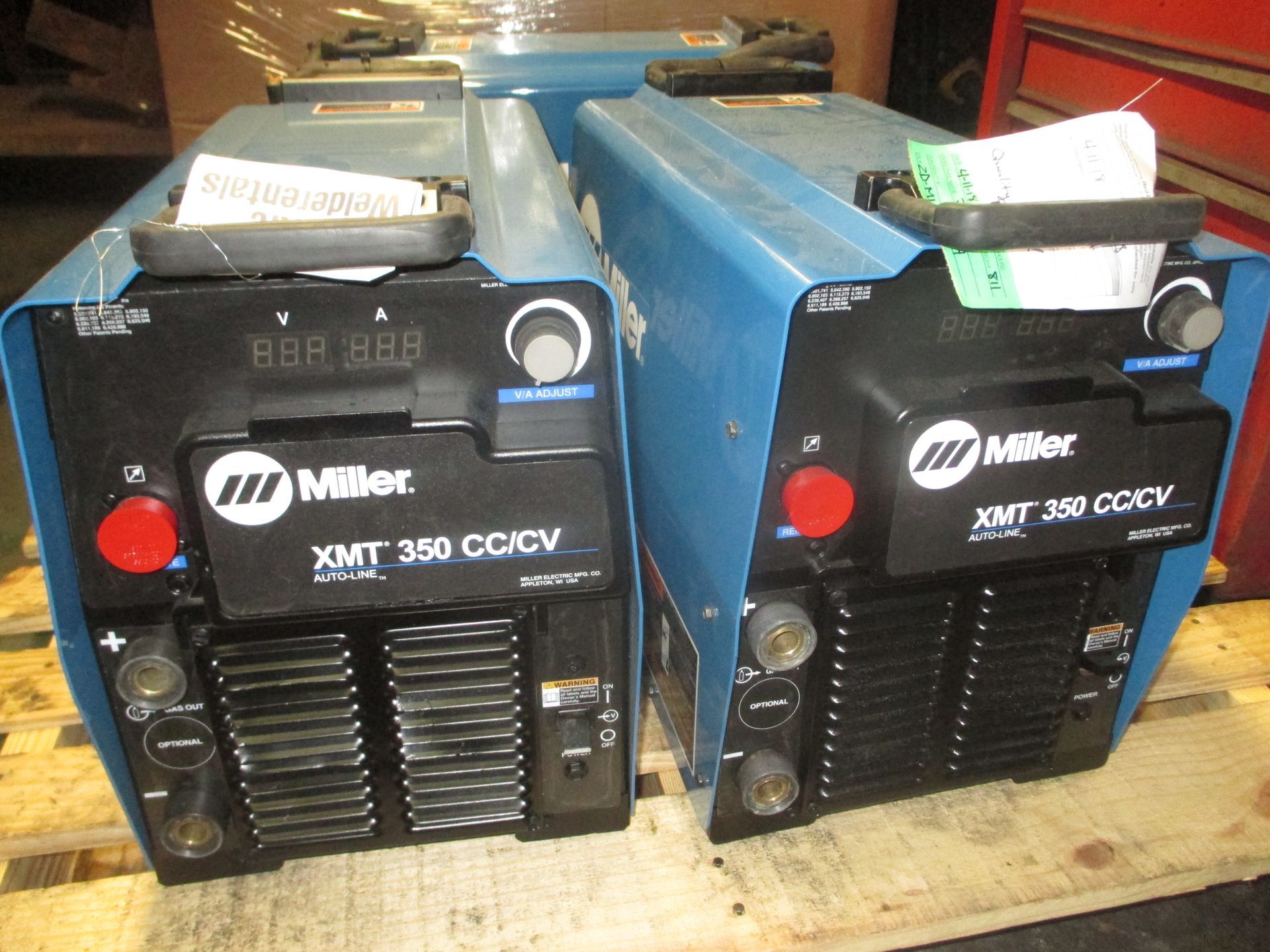 Two miller welding machines are sitting on a wooden pallet