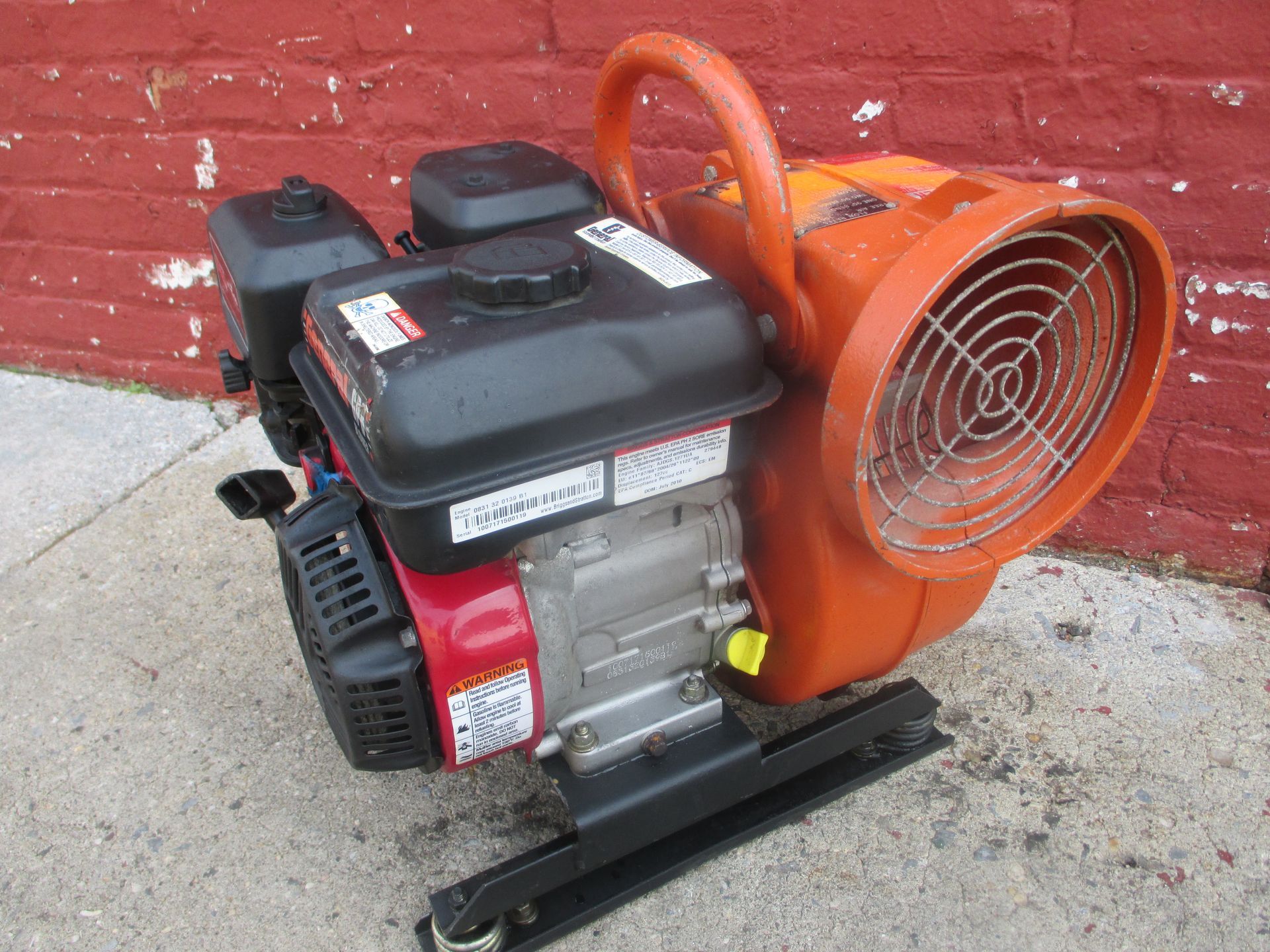 A small engine with an orange fan attached to it