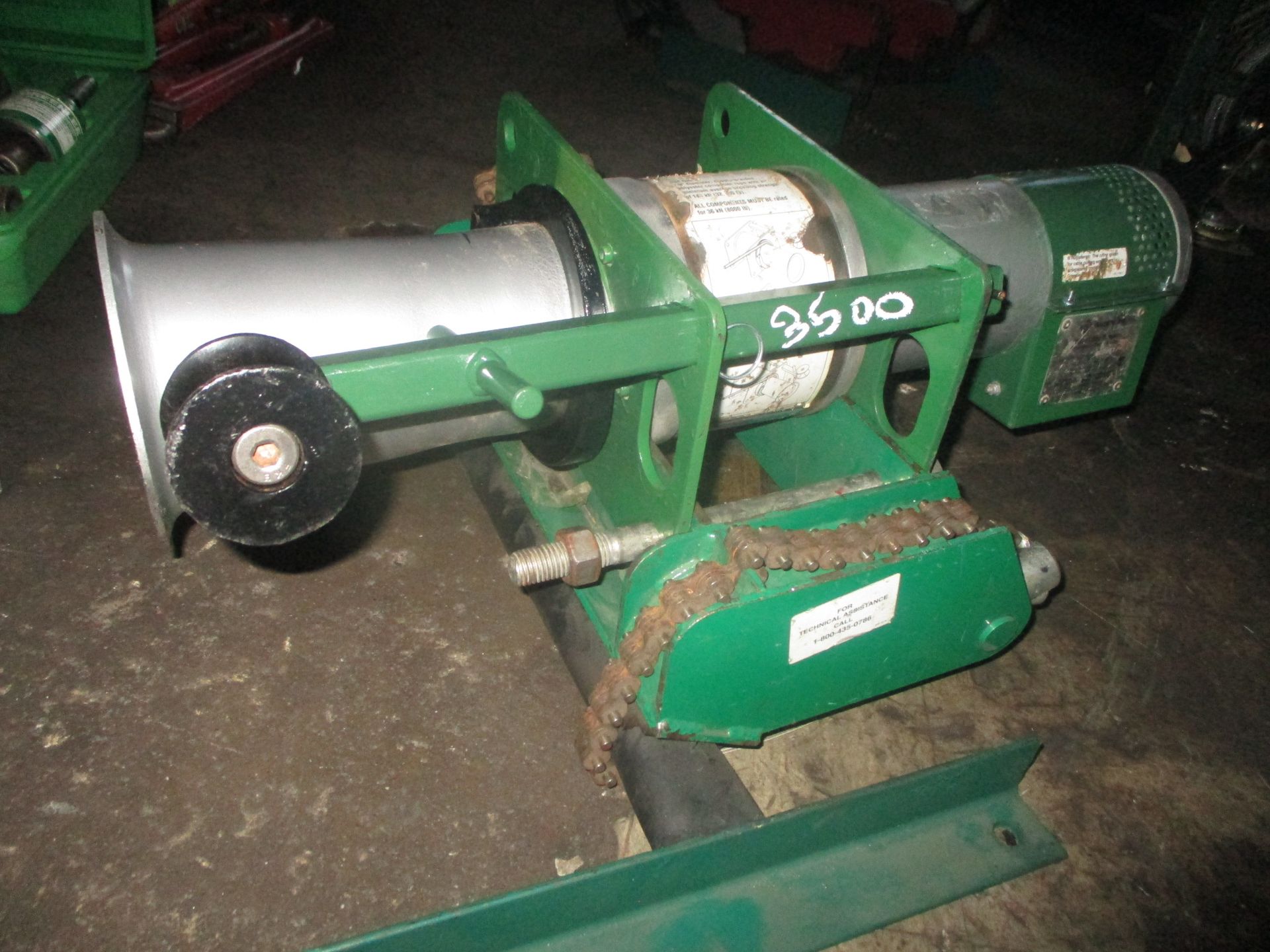 A green and silver winch with the number 3600 on it