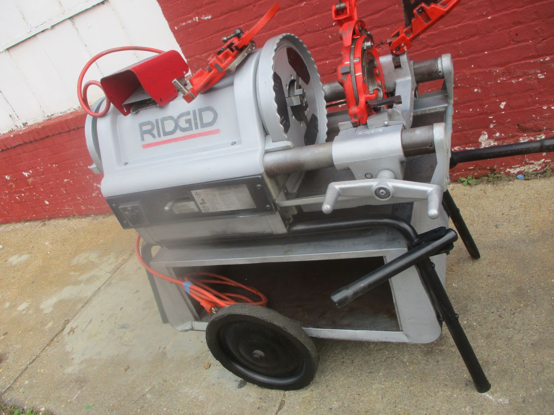 A machine made by ridgid is sitting on a sidewalk