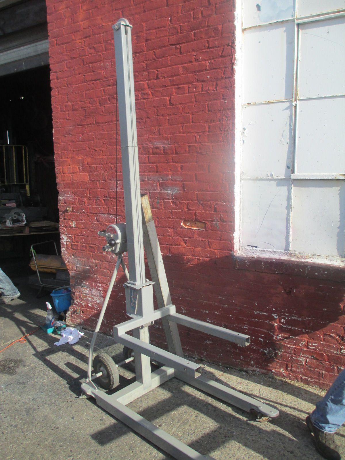 A machine is sitting in front of a red brick building.