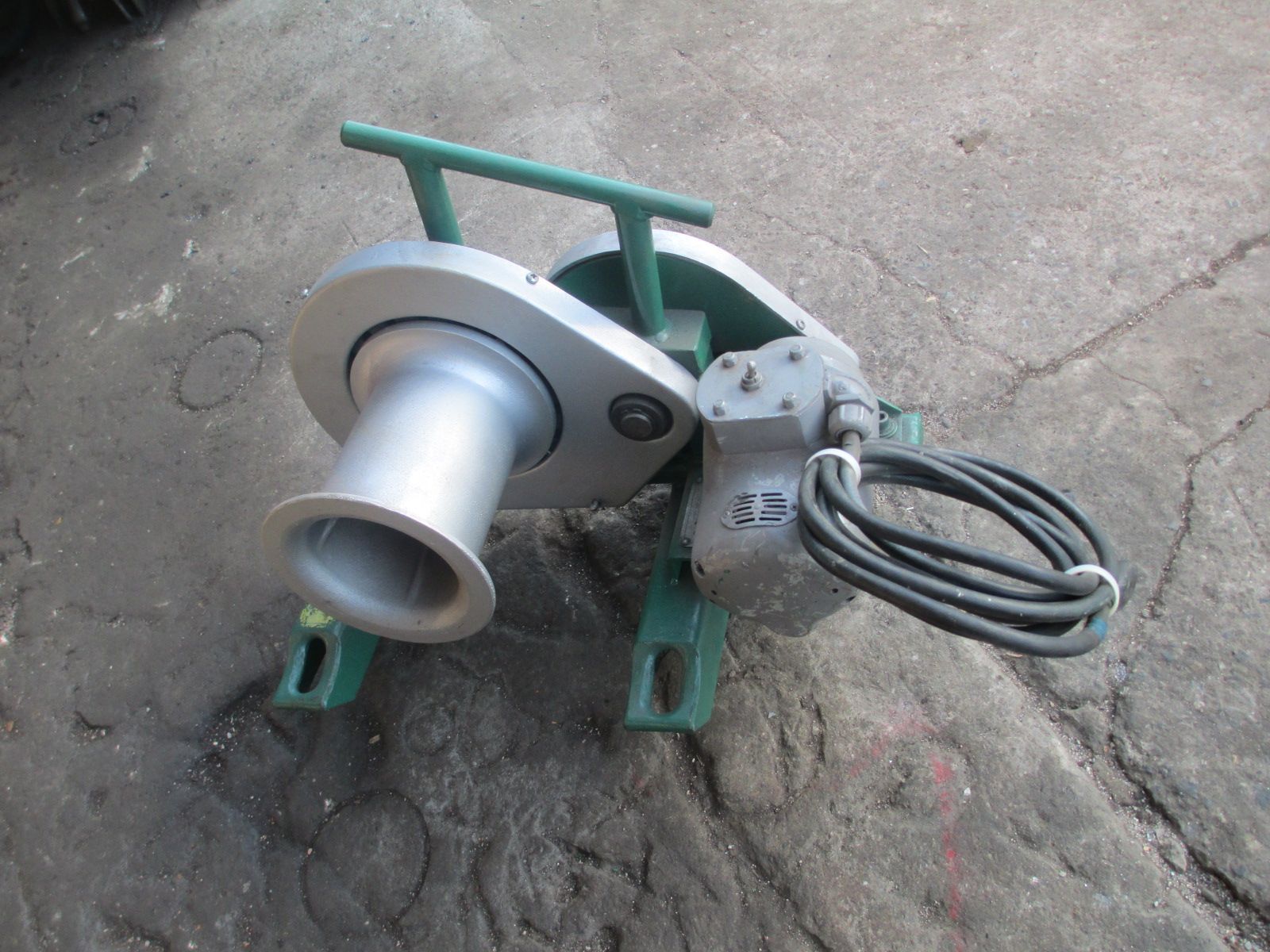A machine with a hose attached to it is sitting on the ground