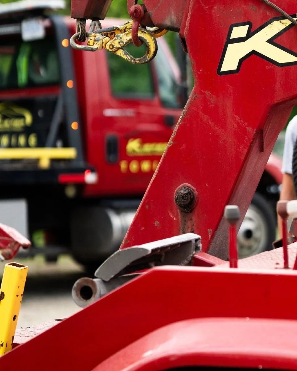 Red fire truck with close-up of a metal hook and red equipment arm in a fire station or lot