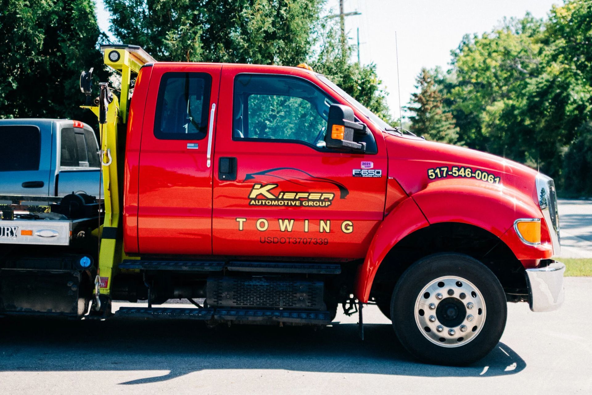 Red tow truck parked outdoors with bright red cab and towing equipment on the back