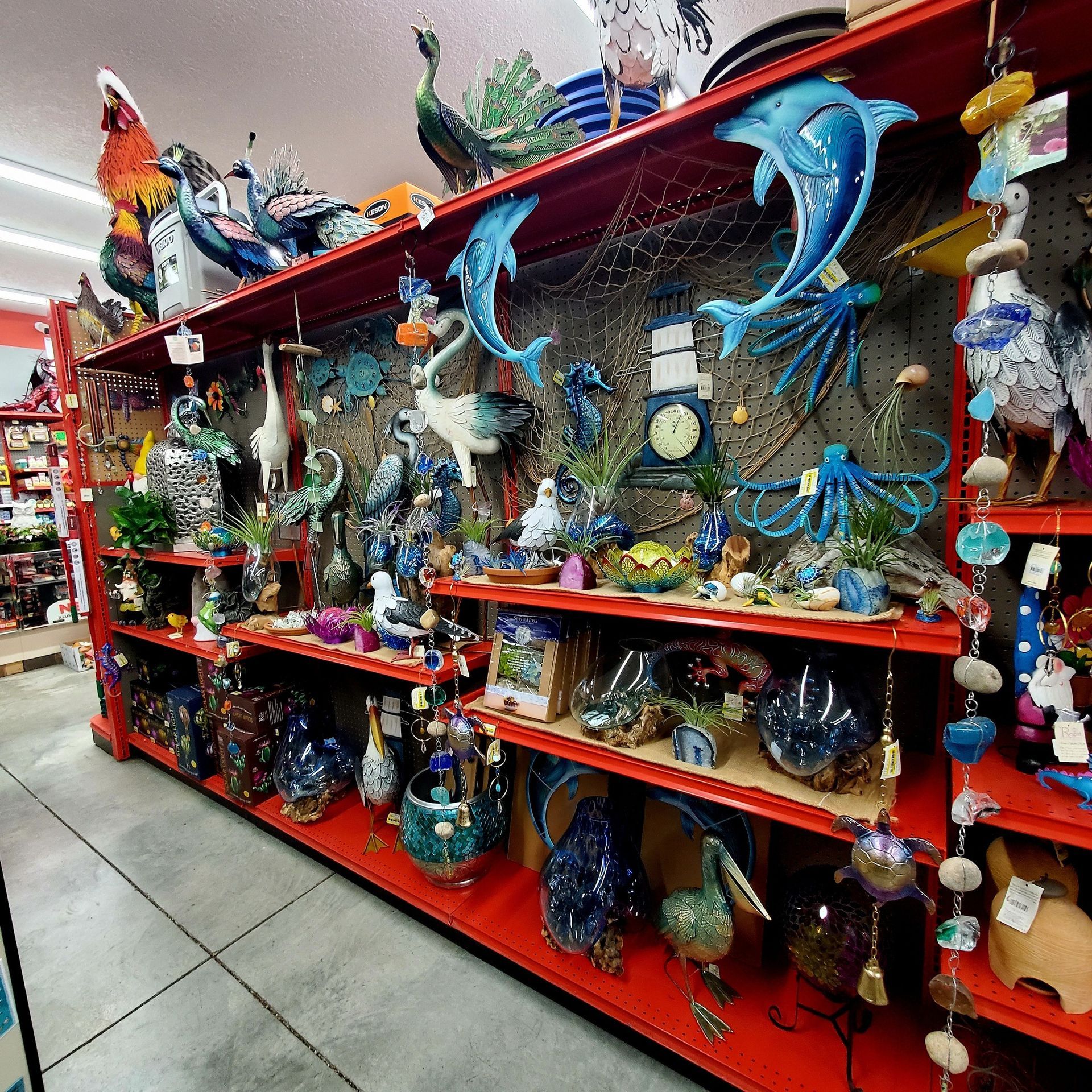 Store shelves filled with colorful sea-themed decorations, including dolphins, fish, and birds, at a retail shop.