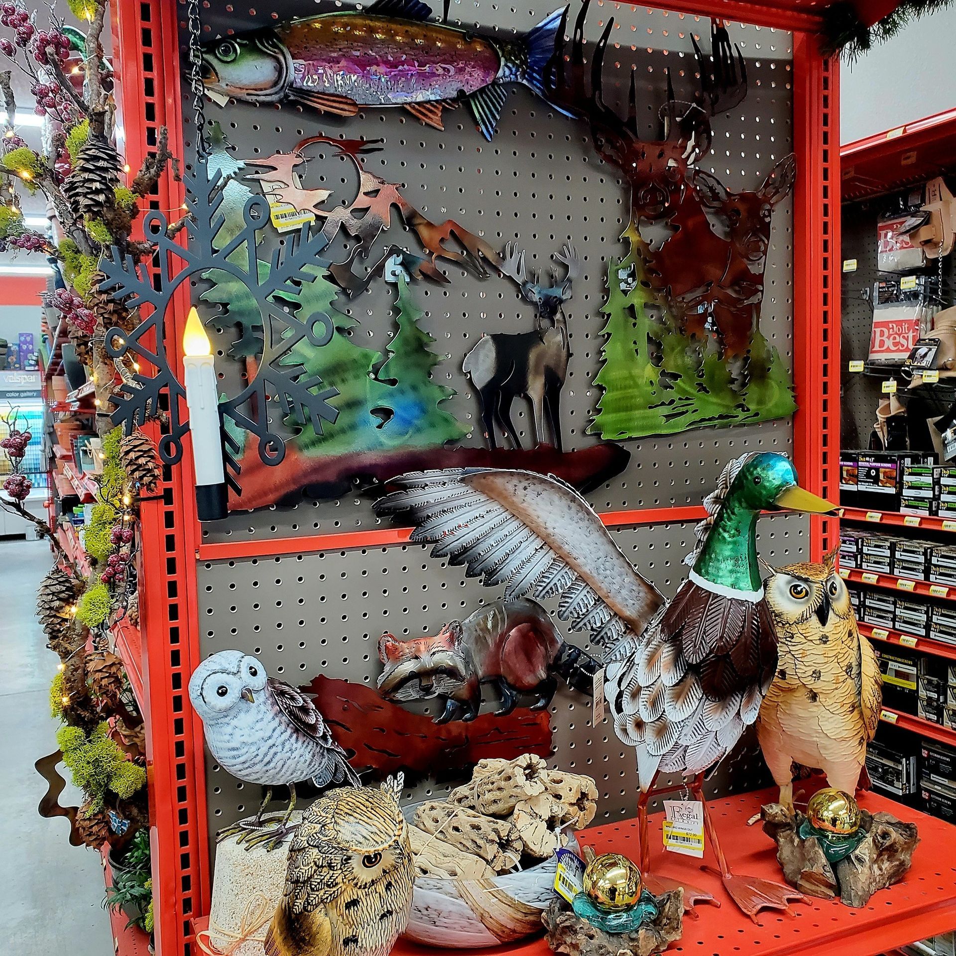 Store shelves filled with decorative metal wildlife art, including a mallard, owl sculptures, and a fish wall hanging.