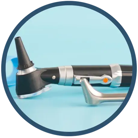 Medical otoscope with speculum on a blue surface.
